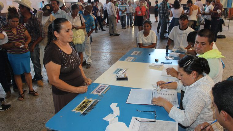Una ciudadana se dispone a emitir su vota y recibe las papeletas de la primera vuelta de elecciones. (Foto Prensa Libre: Hemeroteca PL)  