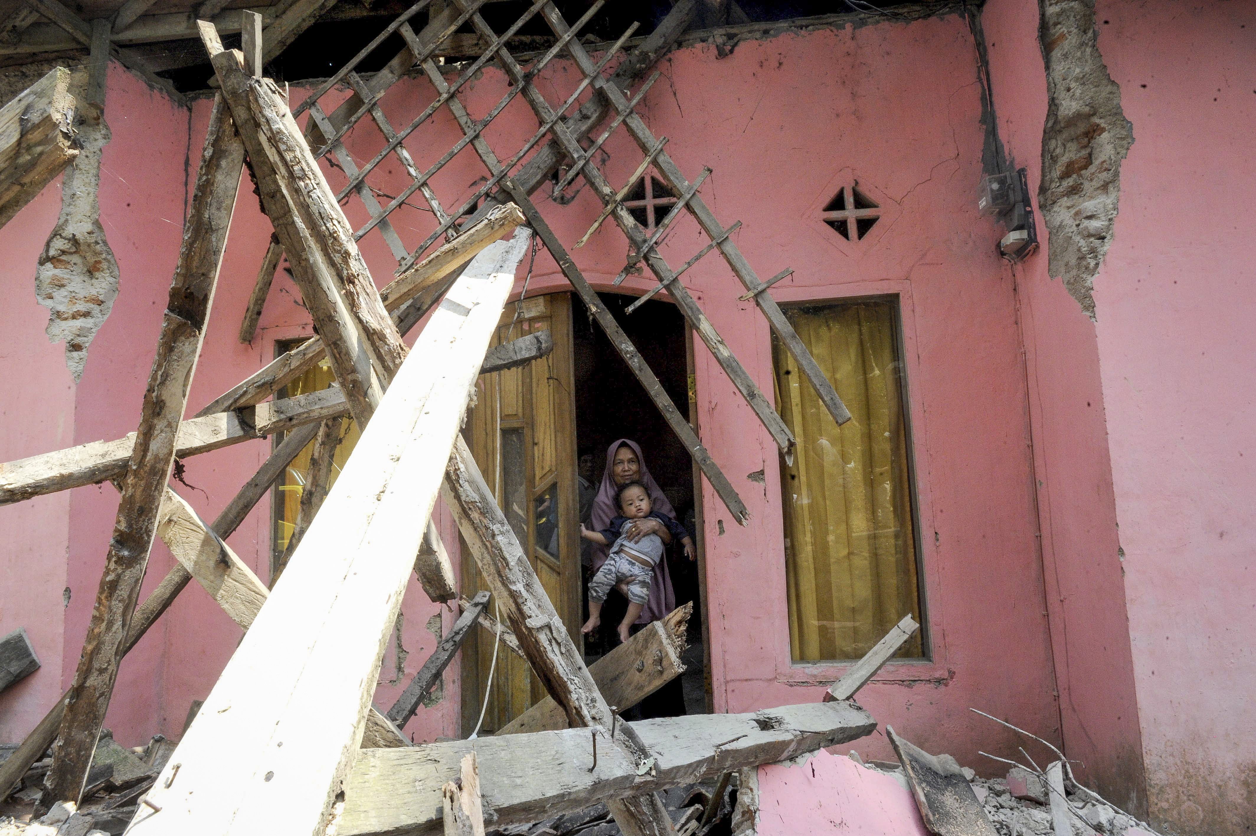 Un residente sale de su casa dañada después de que un terremoto de magnitud 6.9 golpeara el área, en Banten, Indonesia. (Foto Prensa Libre: EFE)