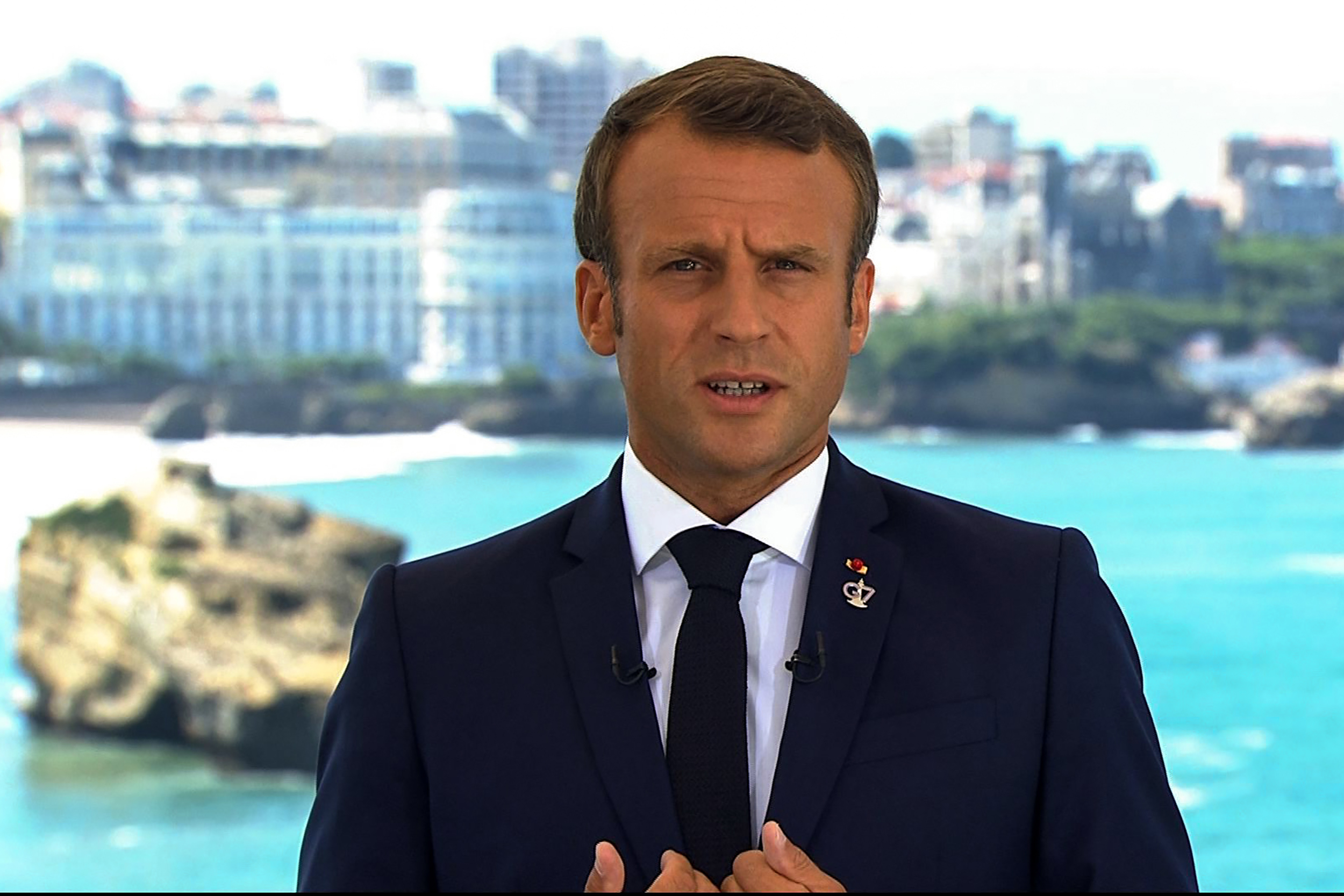 This image grab from footage taken and released by French television channel TF1 shows French President Emmanuel Macron delivering a speech in Biarritz, south-west France on August 24, 2019, on the first day of the annual G7 Summit attended by the leaders of the world's seven richest democracies, Britain, Canada, France, Germany, Italy, Japan and the United States. (Photo by Handout / TF1 / AFP) / RESTRICTED TO EDITORIAL USE - MANDATORY CREDIT "AFP PHOTO / SOURCE / BYLINE" - NO MARKETING - NO ADVERTISING CAMPAIGNS - DISTRIBUTED AS A SERVICE TO CLIENTS