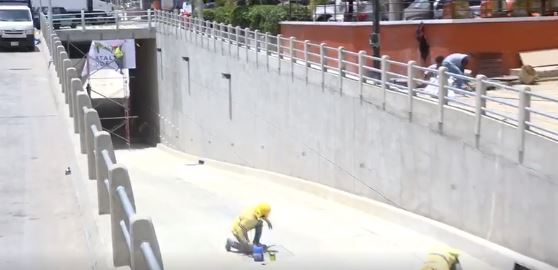Trabajadores municipales afinan los últimos detalles precio a la inauguración del paso a desnivel en la zona 6. (Foto Prensa Libre: Tomada de video de la comuna). 
  
