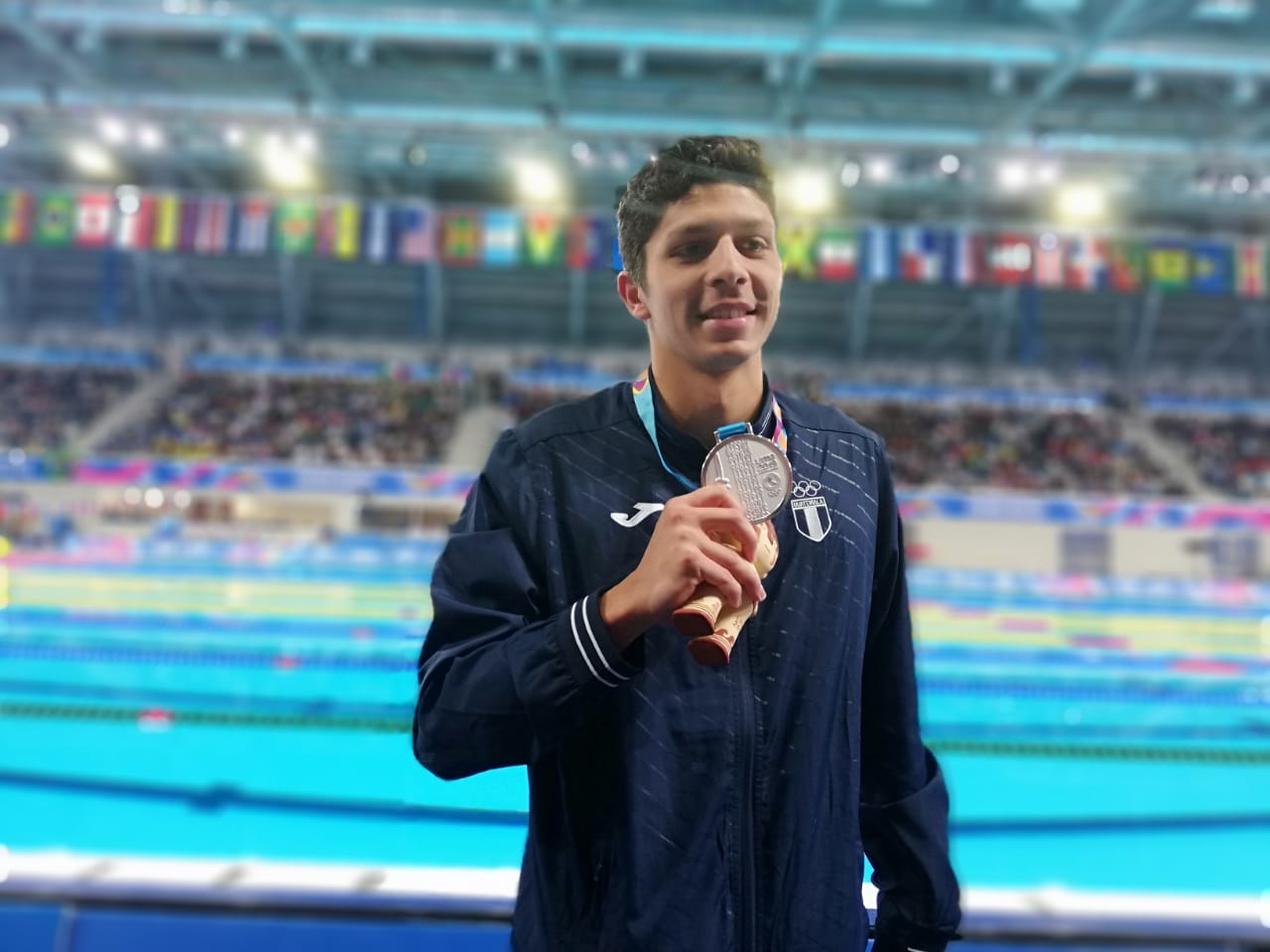 El nadador guatemalteco Luis Carlos Martínez posa con la medalla de plata que conquistó en Lima 2019. (Foto Prensa Libre: Carlos Vicente).
