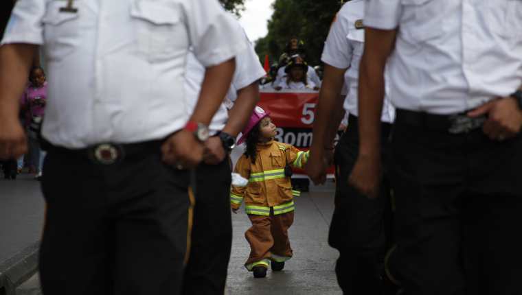 Algunos niños vestidos de bomberos acompañan al pelotón de paramédicos. Fotografía Prensa Libre: Noé Medina.