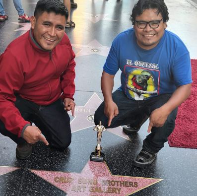 Los hermanos Lorenzo y Pedro Cruz Sunú colocan simbólicamente una estrella en el Paseo de la Fama en Hollywood. (Foto Prensa Libre: Cortesía). 