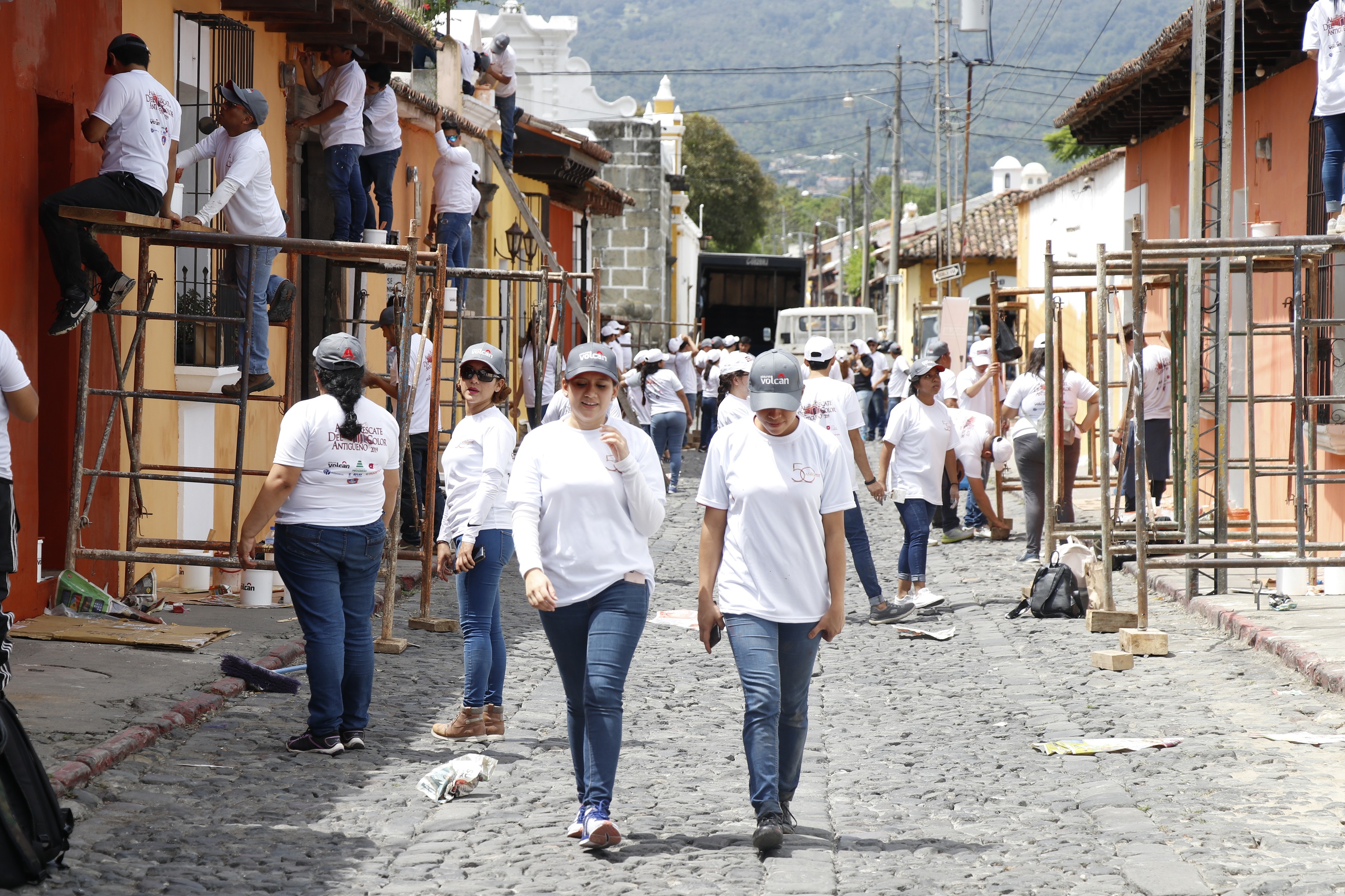 Un grupo de estudiantes de Arquitectura de la UMG participa en la campaña de rescate de los colores antigüeños en el barrio de la Escuela de Cristo de Antigua Guatemala. (Foto Prensa Libre: Julio Sicán)
