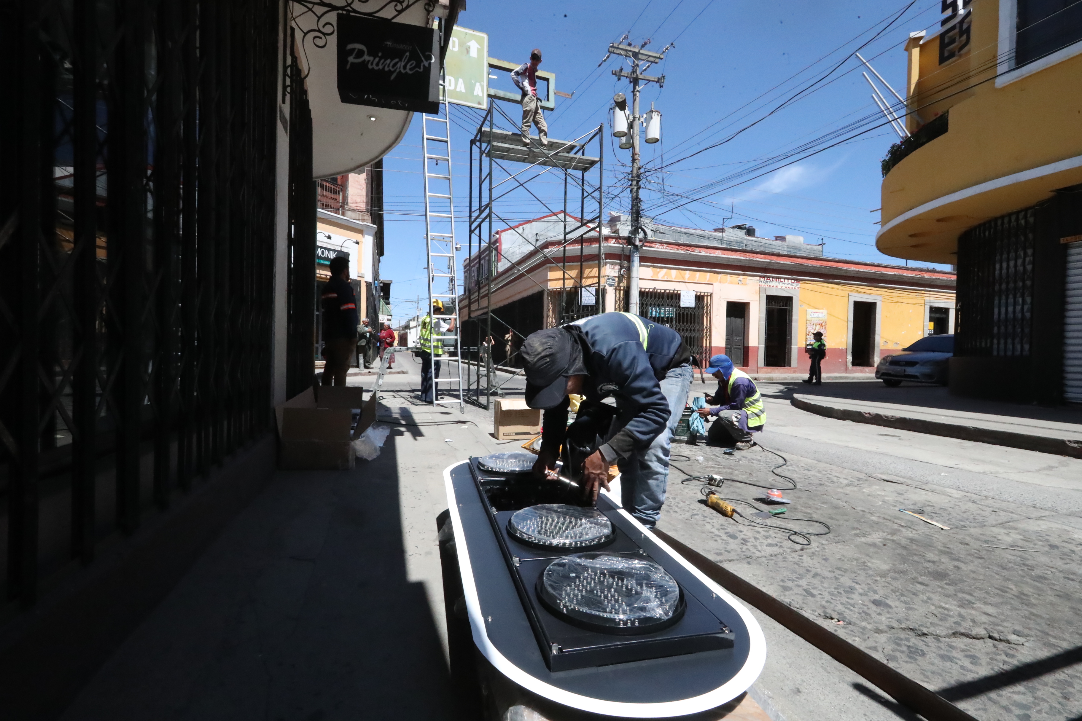 Empleados de la empresa Construartes la 12 revisan uno de los semáforos que instalan en la zona 1 de Xela. (Foto Prensa Libre: Mynor Toc)