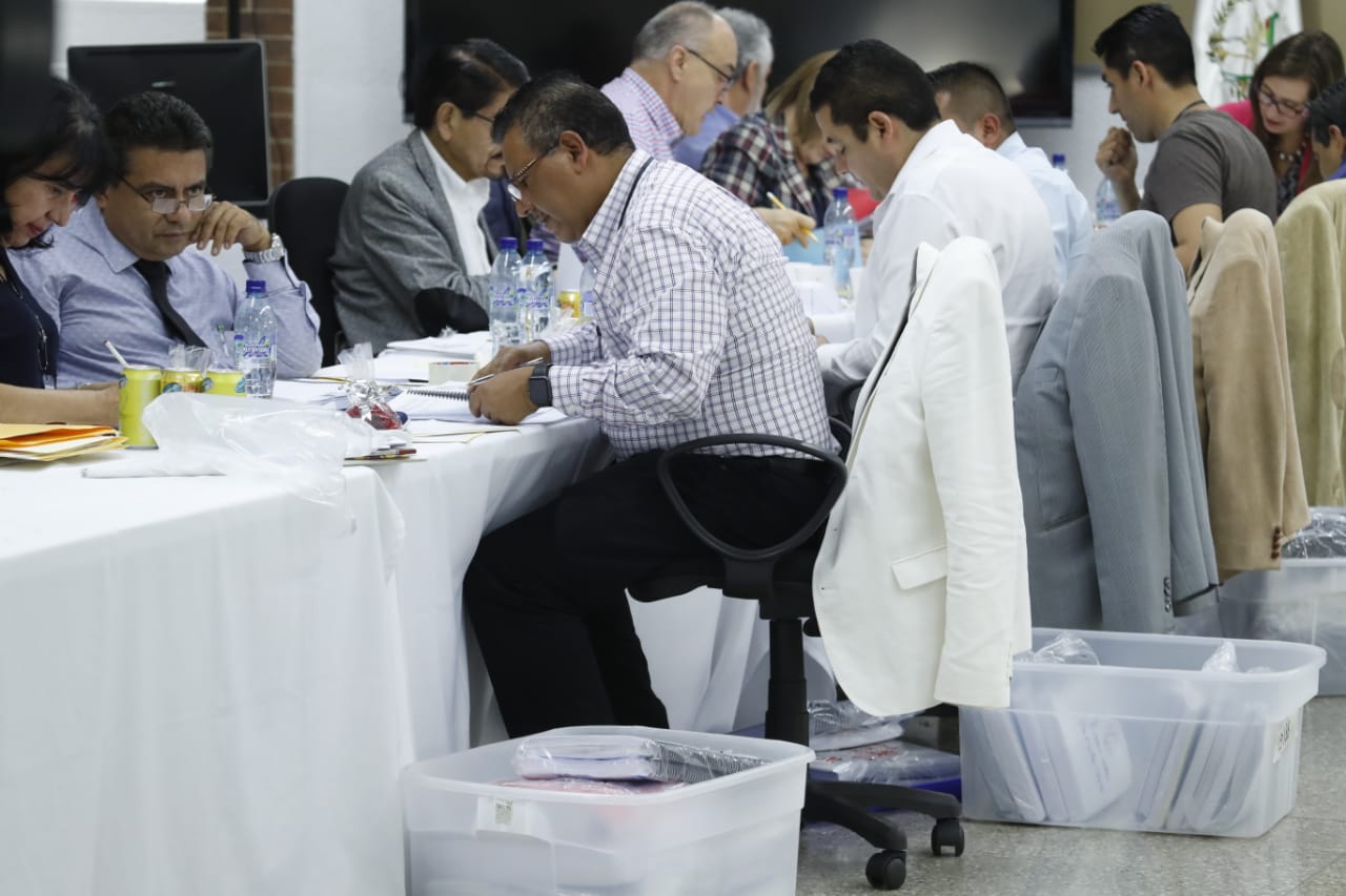 Los postuladores revisan los expedientes de los candidatos a magistrados de la Corte Suprema de Justicia. (Foto Prensa Libre: Esbin García)