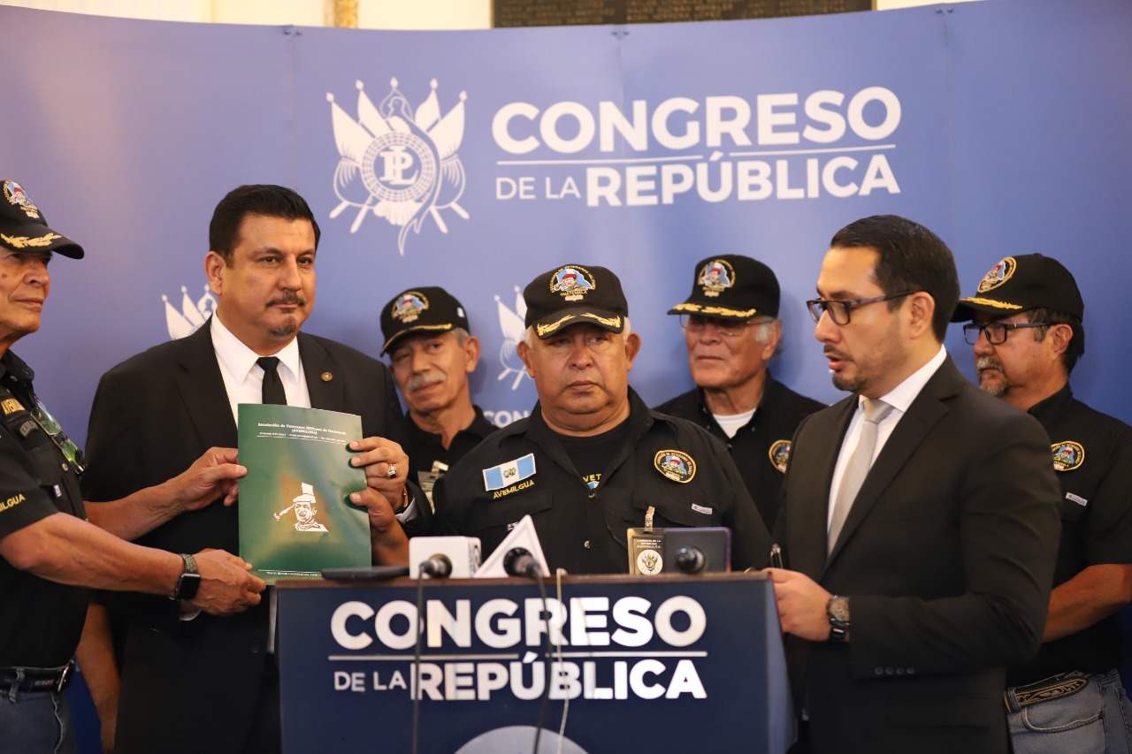 Estuardo Galdámez, primer secretario de la Junta Directiva del Congreso, presenta su iniciativa de ley acompañado de veteranos militares. (Foto Prensa Libre: Congreso)