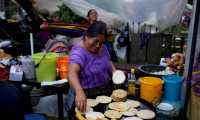GRAF9453. SAN JUAN SACATEPÉQUEZ (GUATEMALA).- Una mujer cocina tortillas y pupusas frente a un centro de votación en el municipio indígena de San Juan Sacatepéquez, hoy domingo 16 con motivo de las elecciones generales de Guatemala. EFE/Esteban Biba
