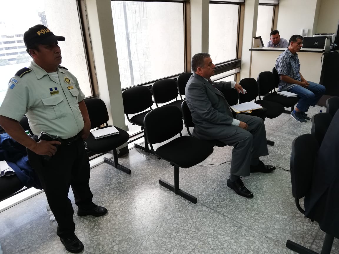 Un agente de la Policía Nacional Civil permanece al lado del viceministro de Gobernación, Remberto Ruiz, durante la audiencia. (Foto Prensa Libre: Kenneth Monzón)
