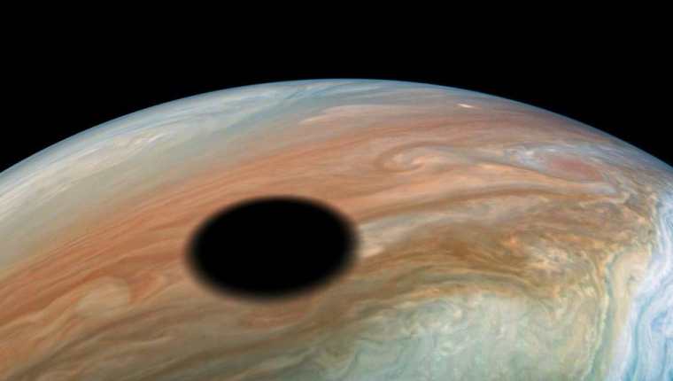 Io es una de cuatro lunas galileas de Júpiter. En esta imagen vemos su sombra reflejada sobre el planeta.