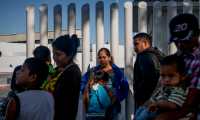 Migrants from Honduras wait in line at the Mexico-United States border crossing in Tijuana, Mexico on September 12, 2019. - With a little help from the Supreme Court and Mexico, US President Donald Trump's fitful crackdown on immigration is finally gaining traction. Trump has spent his entire presidency promising to stop illegal immigration, shut out asylum seekers and wall off the Mexican border.The latest boost came Wednesday when the Supreme Court said he could enact severe restrictions on asylum seekers. The ruling requires would-be refugees to ask for asylum in the first country they visit and only then -- if they are rejected -- can they attempt to apply in the United States. (Photo by SANDY HUFFAKER / AFP)