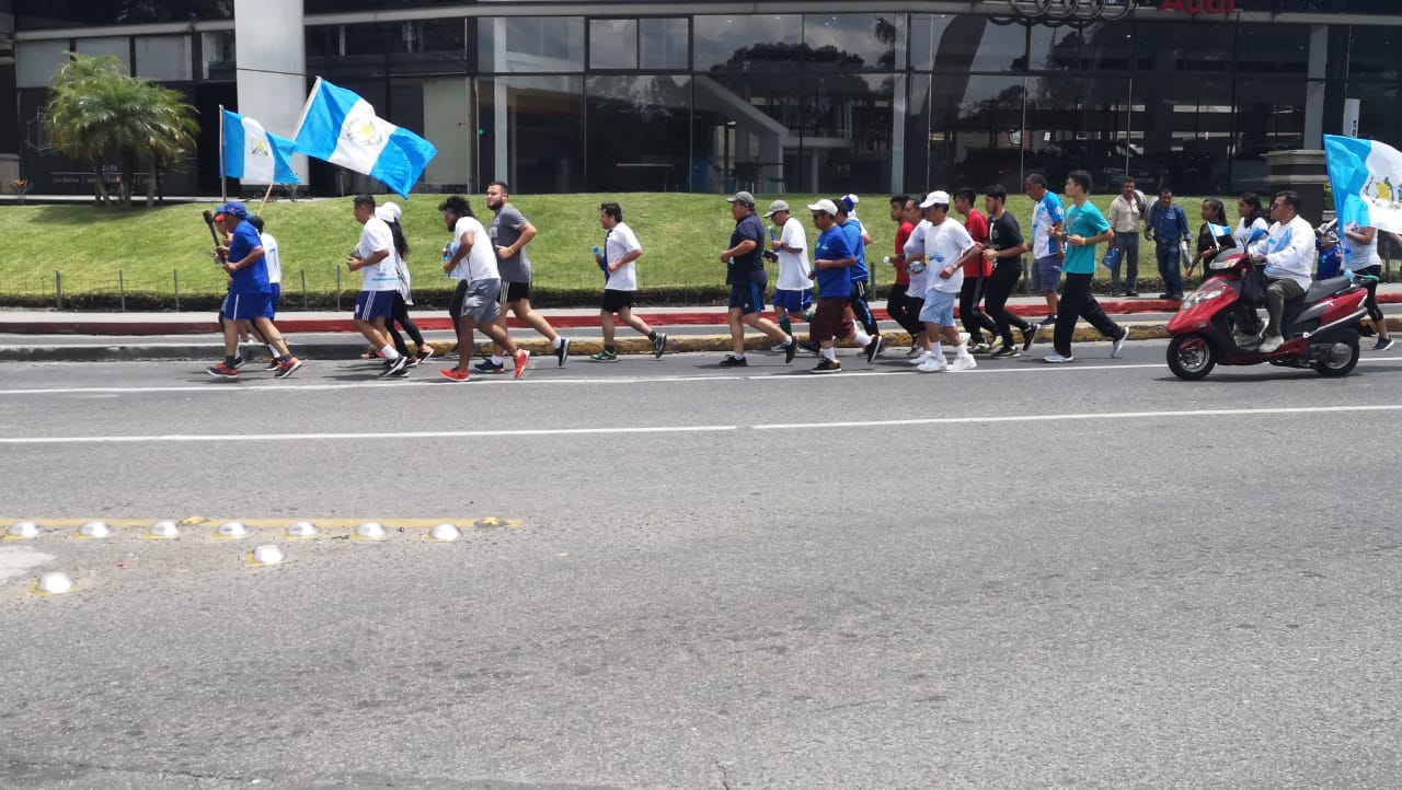 Grupo de personas corre con la antorcha en las cercanías del Obelisco. (Foto Prensa Libre).
