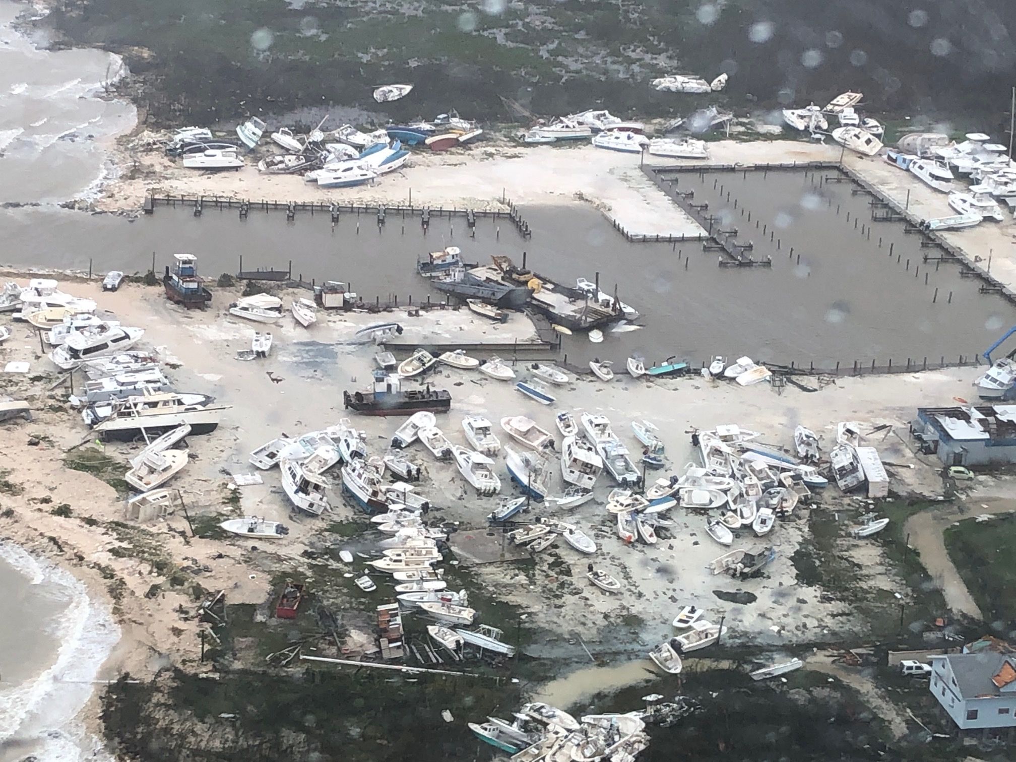 In this image courtesy of US Coast Guard Air Station Clearwater, boats are strewn across a marina in the Bahamas on September 2, 2019, as Hurricane Dorian makes its way across the Bahamas. - Dorian crept towards the southeast coast of the US on September 3, 2019, weakening slightly but remaining a dangerous storm after leaving a trail of death and destruction in the Bahamas. At least five deaths have been reported in the Bahamas from a storm which Prime Minister Hubert Minnis called a "historic tragedy" for the Atlantic archipelago.The Miami-based National Hurricane Center said Dorian, which has dumped as much as 30 inches (76 centimeters) of rain on the Bahamas, had been downgraded from a Category 3 to a Category 2 storm on the five-level wind scale. (Photo by HO / US Coast Guard / AFP) / RESTRICTED TO EDITORIAL USE - MANDATORY CREDIT "AFP PHOTO / US COAST GUARD" - NO MARKETING NO ADVERTISING CAMPAIGNS - DISTRIBUTED AS A SERVICE TO CLIENTS