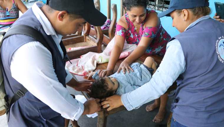 Los integrantes del Comusan comprueban el peso y talla de los menores que visitados en sus casas de Puerto San José, Escuintla. (Foto Prensa Libre: Carlos Paredes)