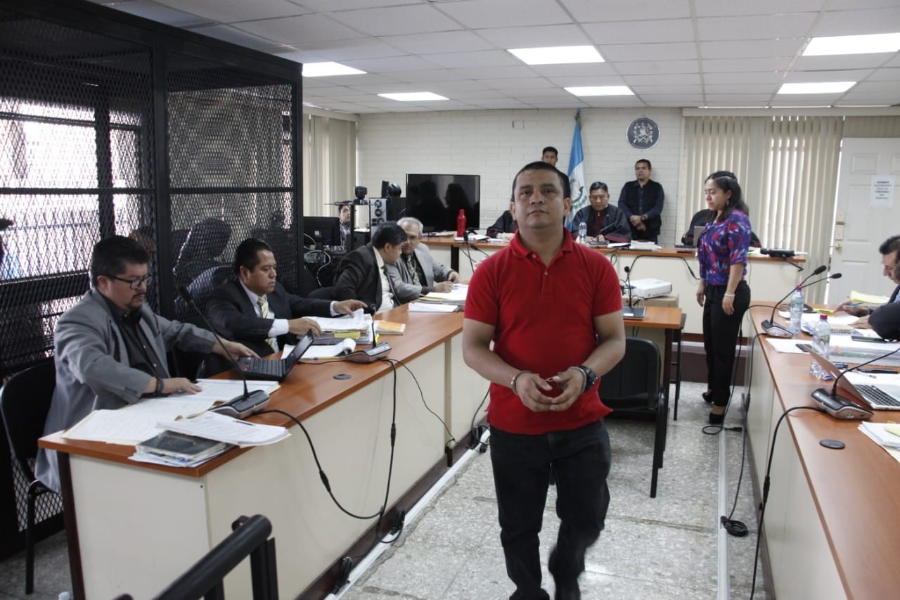 El exagente de la PNC Miguel Silvano Gómez Toma regresa a su silla luego de exponer ante el juez su "inocencia" en los crímenes. (Foto Prensa Libre: Noé Medina) 