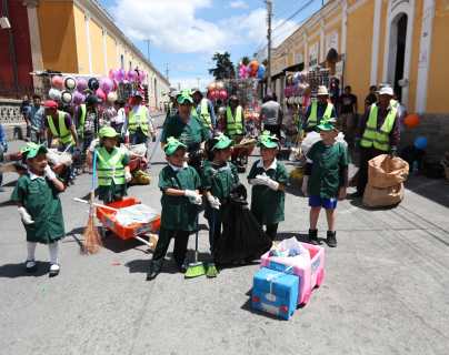 Niños de párvulos ayudan a recolectar la basura que quedó tirada durante el desfile