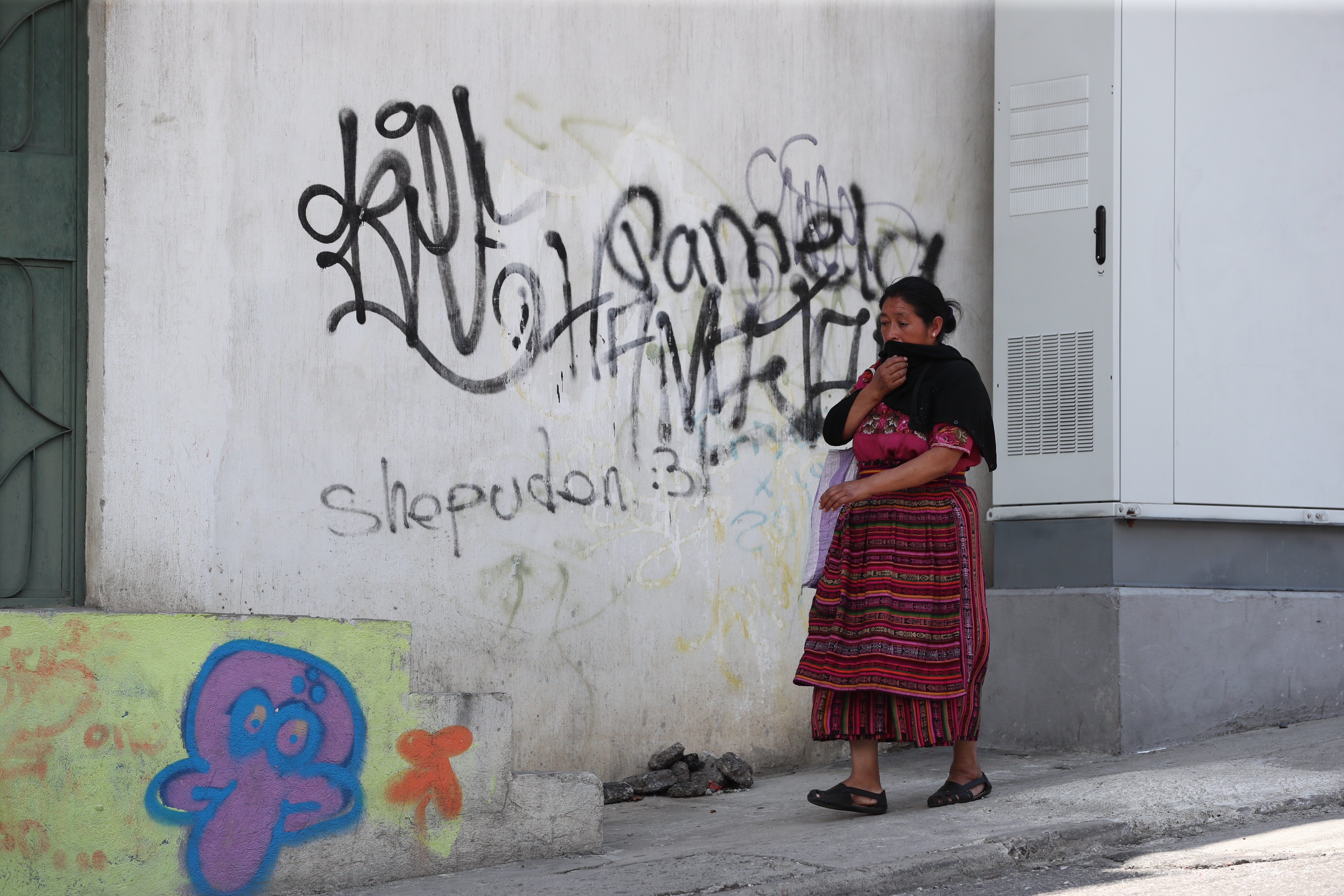 Una vecina camina frente a un grafitti pintado en una de las paredes de un inmueble del bulevar principal de Prados de Villa Hermosa. (Foto Prensa Libre: Érick Ávila) 