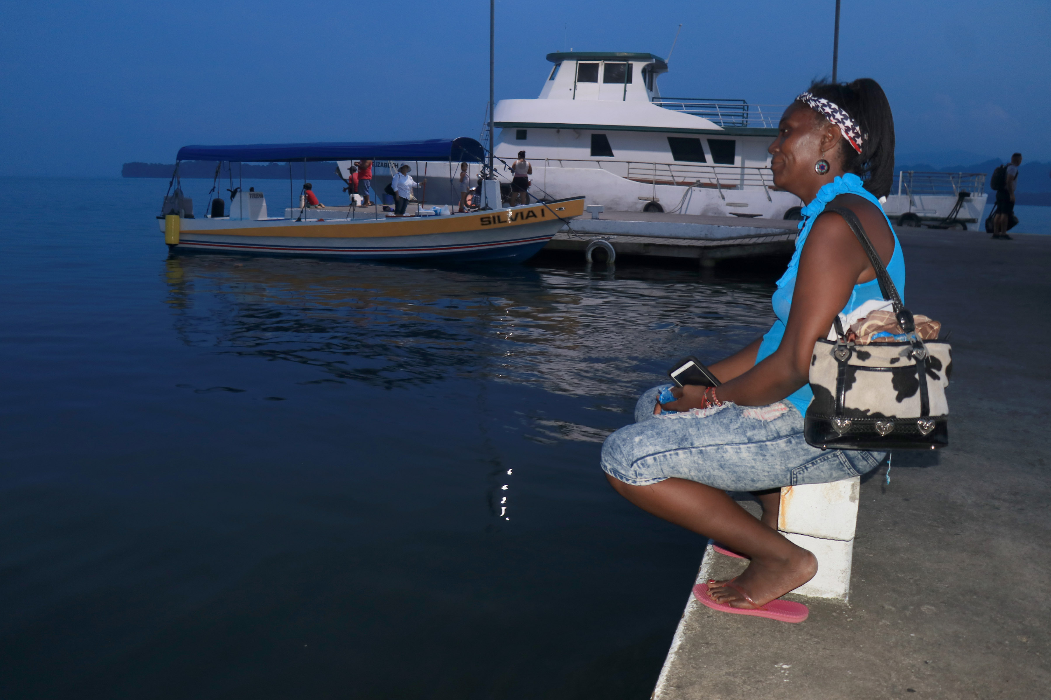 Claudia Flores de Lívingston observa la llegada de pocas embarcaciones al muelle del lugar,  expresa que el estado de Sitio ha representado baja en turismo en la localidad. (Foto, Prensa Libre: Dony Stewart).