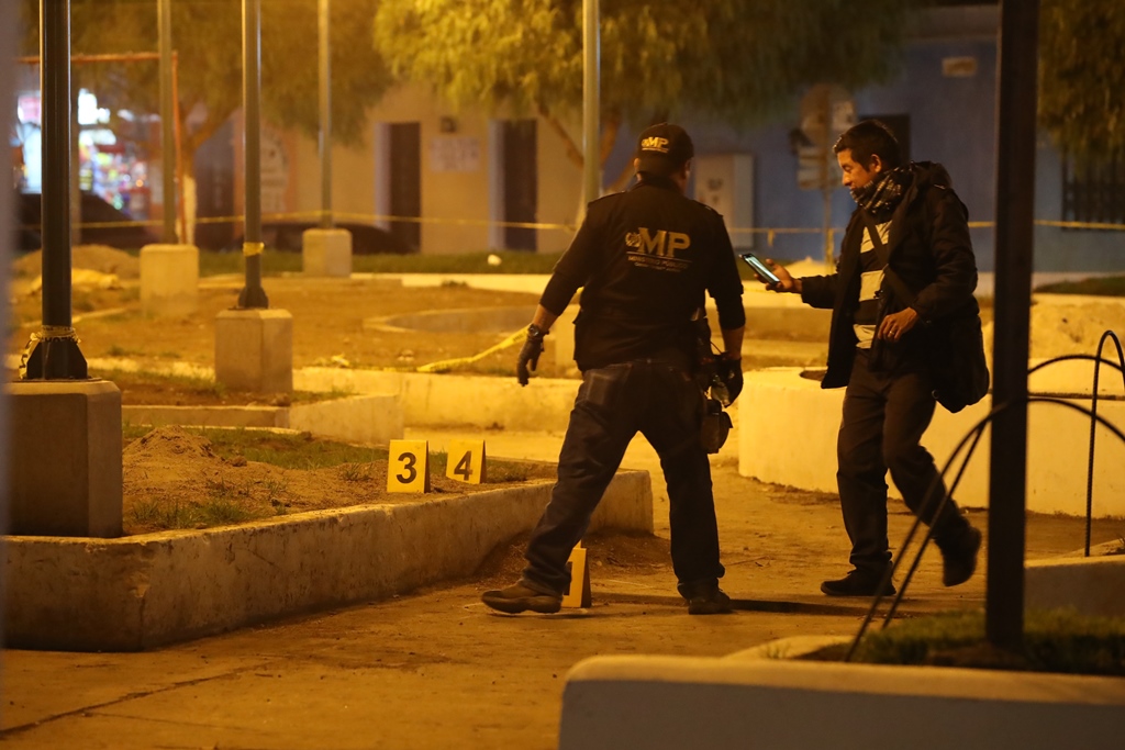 Dos investigadores del Ministerio Público marcan el lugar donde localizaron los cascabillos. (Foto Prensa Libre: Mynor Toc)