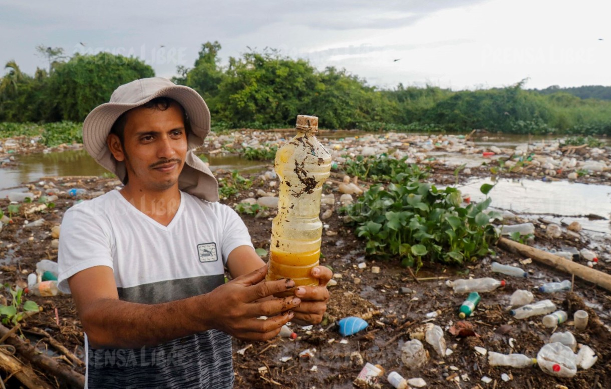 Poblador muestra una botella de aceite que supuestamente llegó  desde la cabecera de Retalhuleu hasta la reserva Manchón Guamuchal. (Foto Prensa Libre: Rolando Miranda)