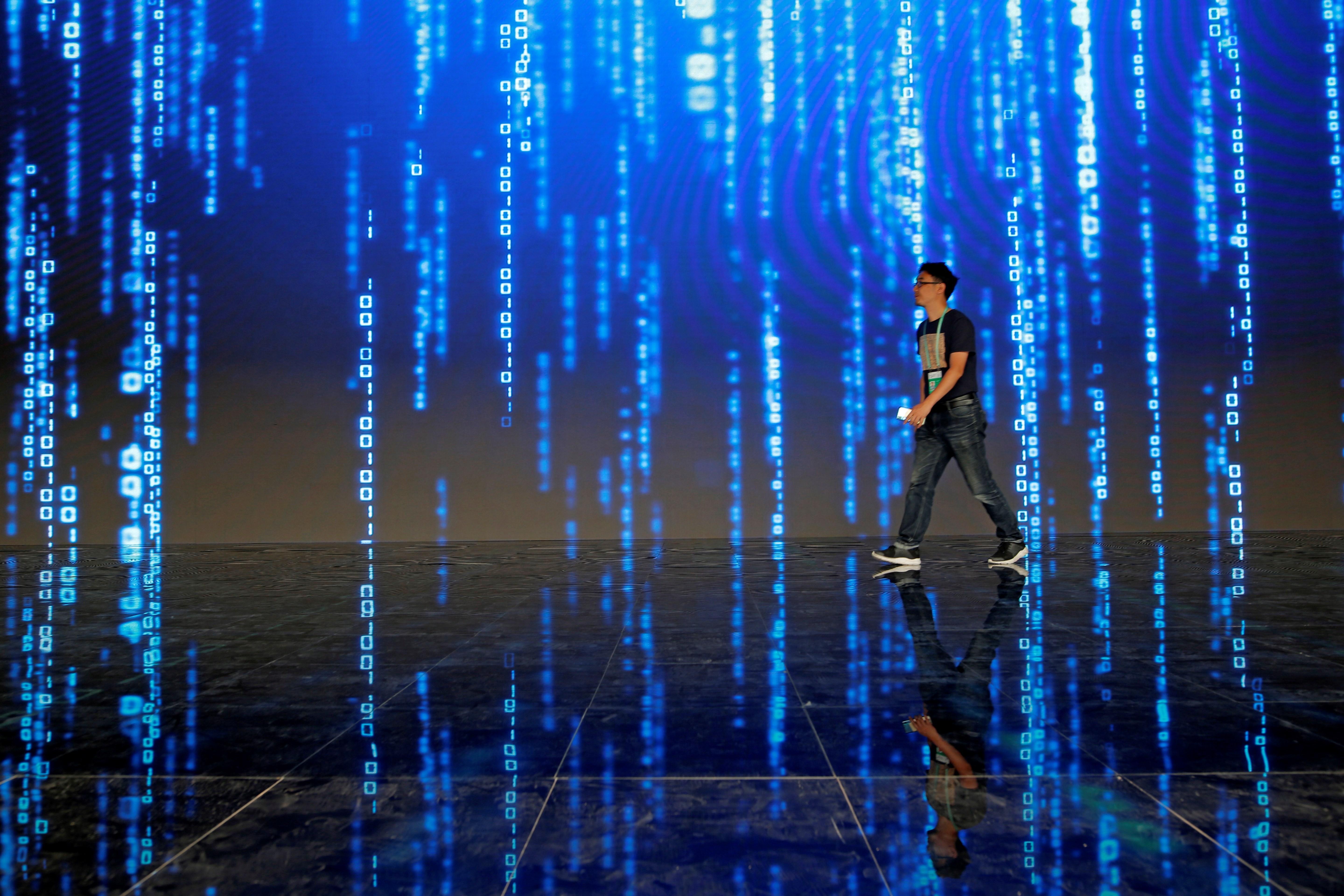 AME8515. WUZHEN (CHINA), 31/10/2019.- Un visitante pasa el 21 de octubre de 2019 por una pantalla que simula el flujo de datos en Internet, durante la sexta Conferencia Mundial de Internet, en Wuzhen (China). El 50 aniversario de Internet es uno de los clics tecnológicos de la semana en América. Internet, la red global de comunicaciones que ha revolucionado a la humanidad, cumplió 50 años. A las 22.00 horas del 29 de octubre de 1969, el científico Leonard Kleinrock y su equipo enviaron desde su laboratorio en la Universidad de California Los Ángeles (UCLA) el primer mensaje con solo dos letras, 