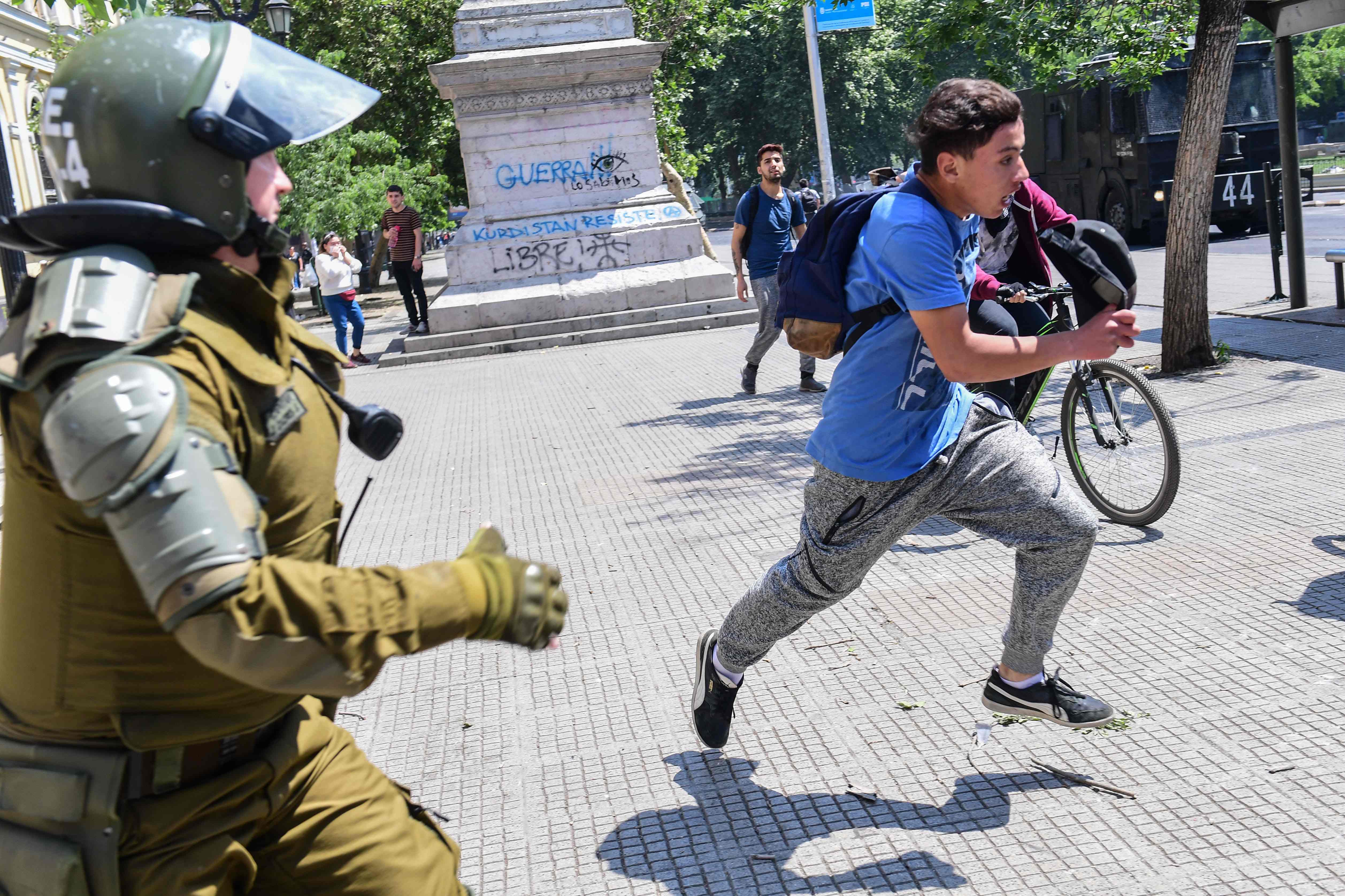La policía persigue a un manifestante durante los enfrentamientos con la policía en Santiago este 20 de octubre. (Foto Prensa Libre: AFP)