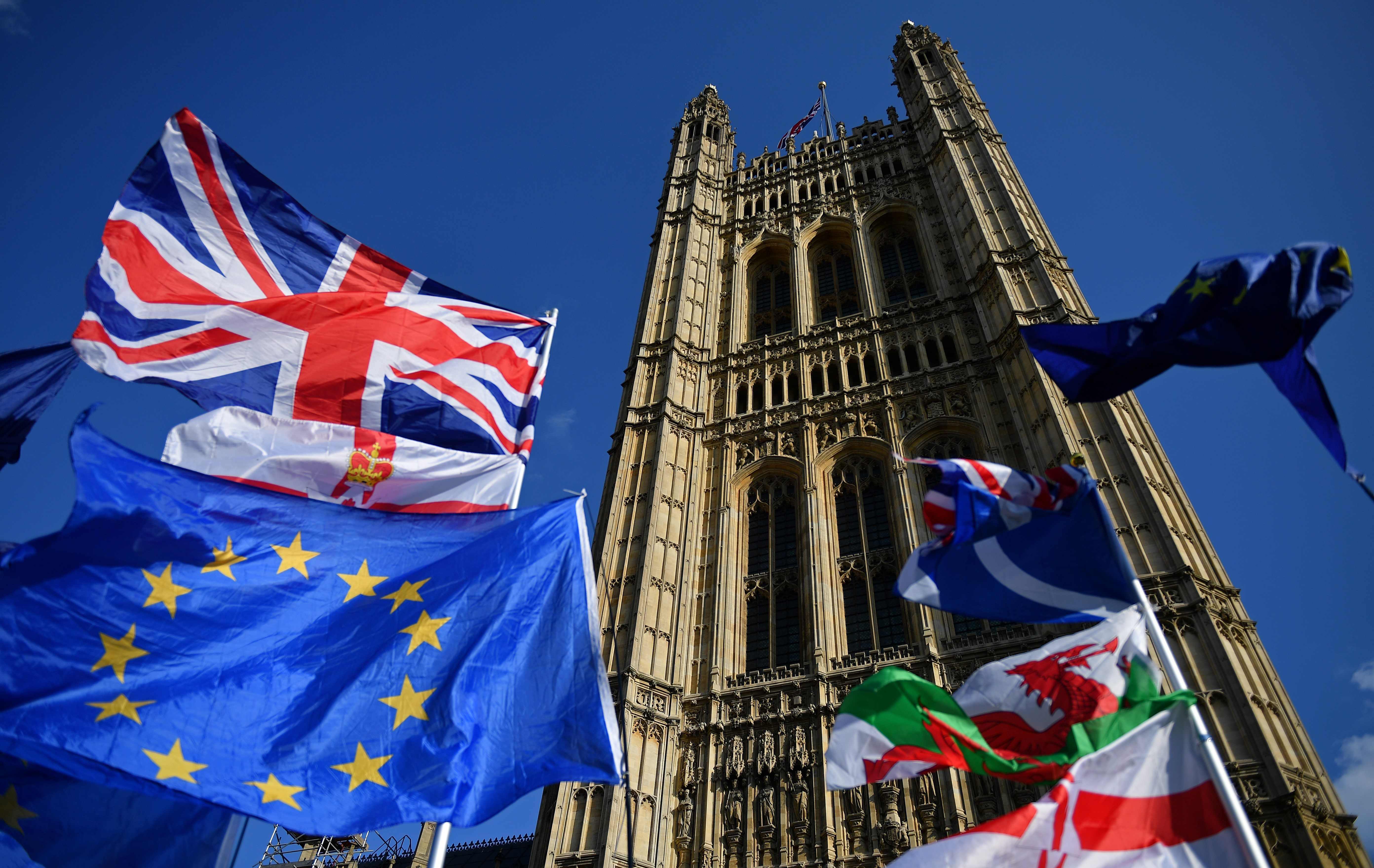 Las banderas pertenecientes a activistas anti-Brexit y pro-Brexit vuelan fuera de las Casas del Parlamento en Londres cuando los parlamentarios comienzan a debatir la segunda lectura del proyecto de ley de Acuerdo de Retirada. (Foto Prensa Libre AFP)