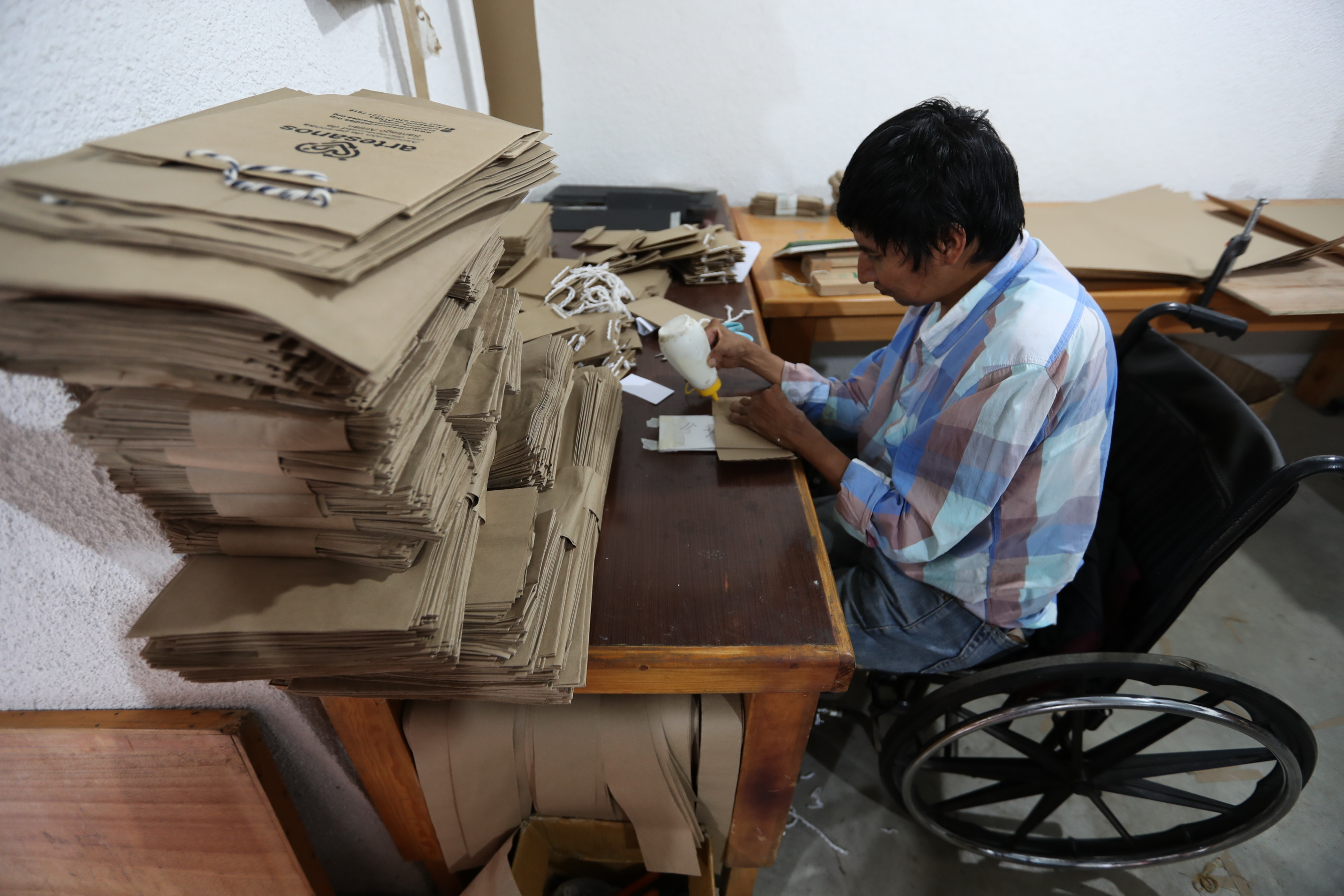 Diego Ramírez Xicay trabaja en el pegado de las bolsas en la Asociación Adisa, Santiago Atitlán, Sololá. (Foto Prensa Libre: César Pérez)