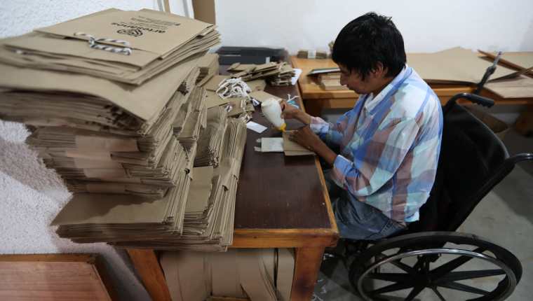 Diego Ramírez Xicay trabaja en el pegado de las bolsas en la Asociación Adisa, Santiago Atitlán, Sololá. (Foto Prensa Libre: César Pérez)