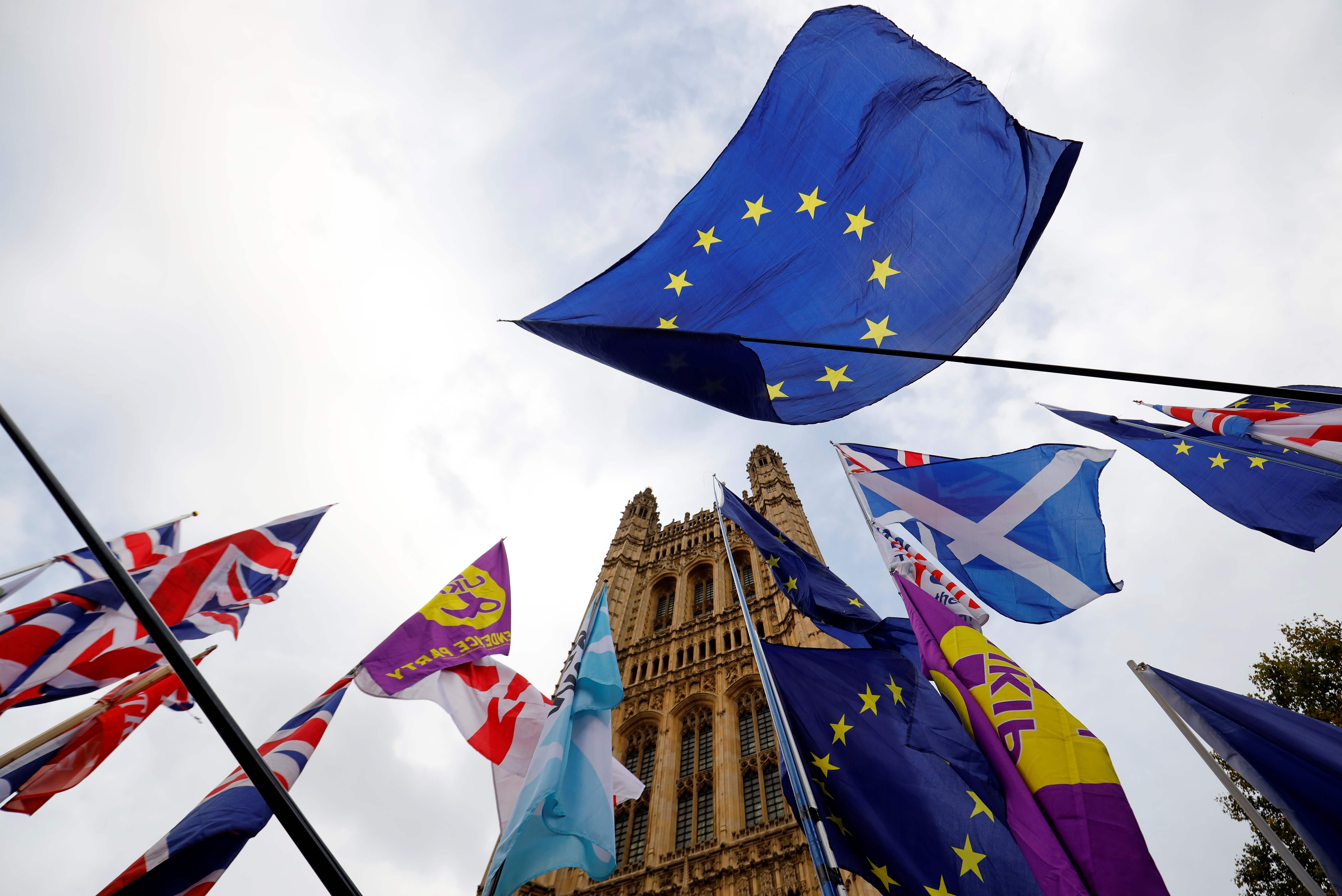 Las banderas de la UE de los activistas anti-Brexit se muestran junto a las banderas de la Unión de activistas pro-Brexit mientras se manifiestan fuera de las Casas del Parlamento en Londres. (Foto Prensa Libre: AFP)