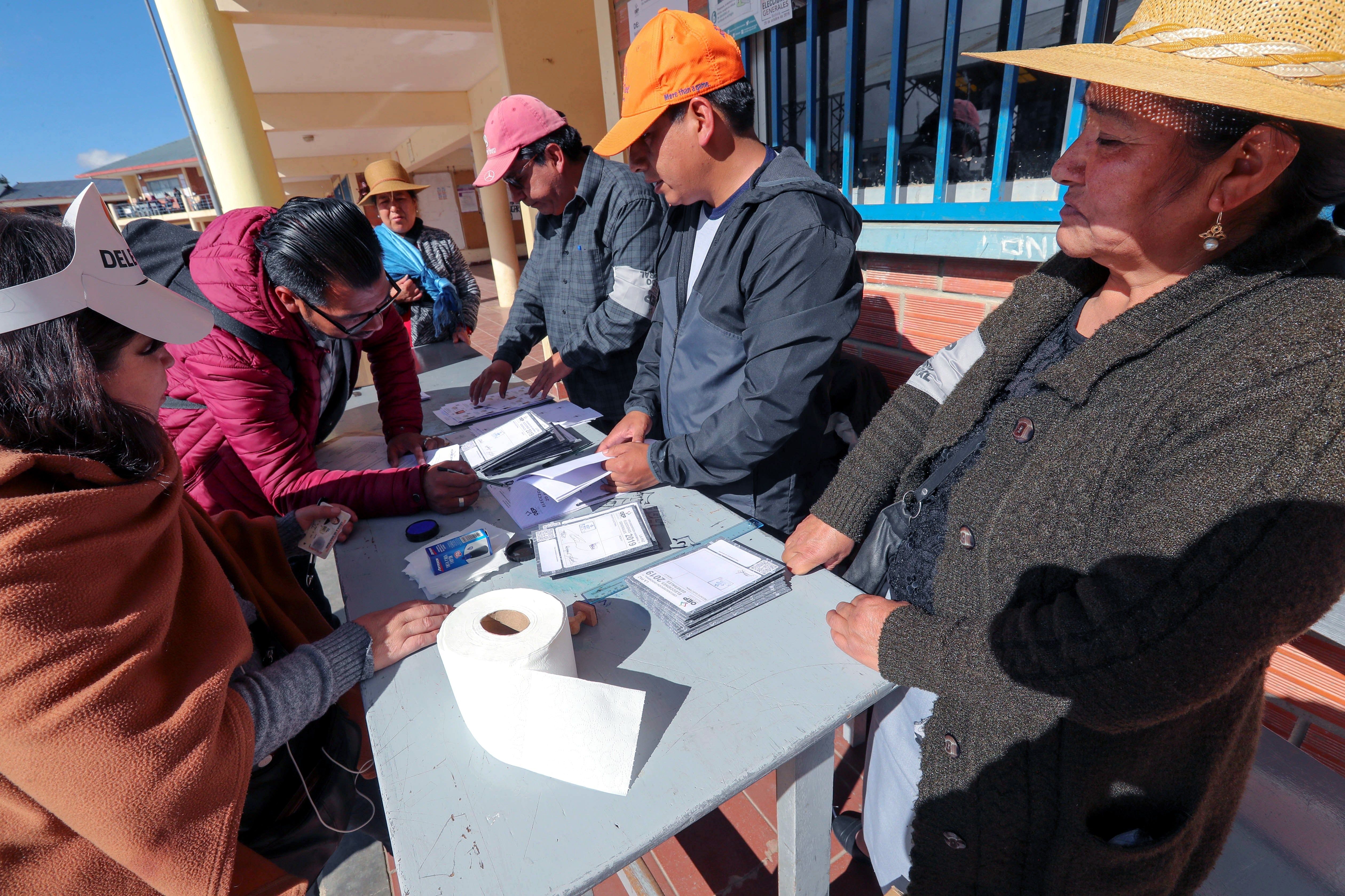 GRAF4182. EL ALTO (BOLIVIA), 20/10/2019.- Jurados electorales preparan la apertura de la jornada electoral de este domingo en El Alto (Bolivia). La jornada de comicios generales en Bolivia, en la que se elegirá al presidente y vicepresidente y se renovará el Parlamento para el periodo 2020-2025, comenzó este domingo con la apertura de las mesas electorales. EFE/ Martin Alipaz