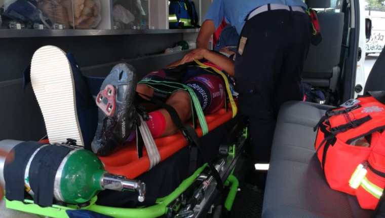 El ciclista Wederley Pérez es auxiliado por bomberos. (Foto Prensa Libre: Carlos Vicente). 