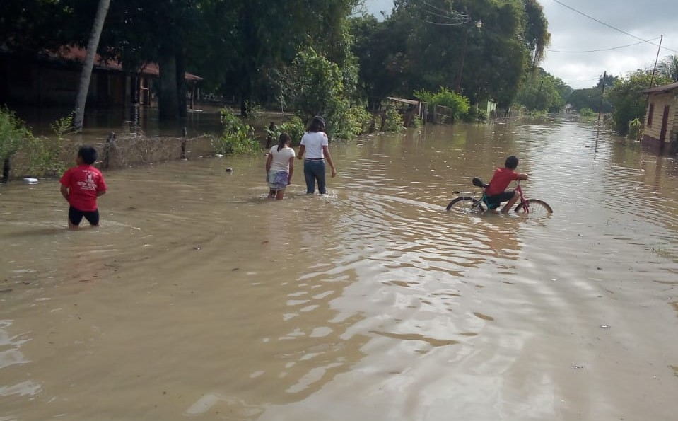 Vecinos de Las Cruces, Petén, camina entre el agua y luego que anega las calles del pueblo, debido a la fuerte lluvia que azota esa región. (Foto Prensa Libre: Conred)