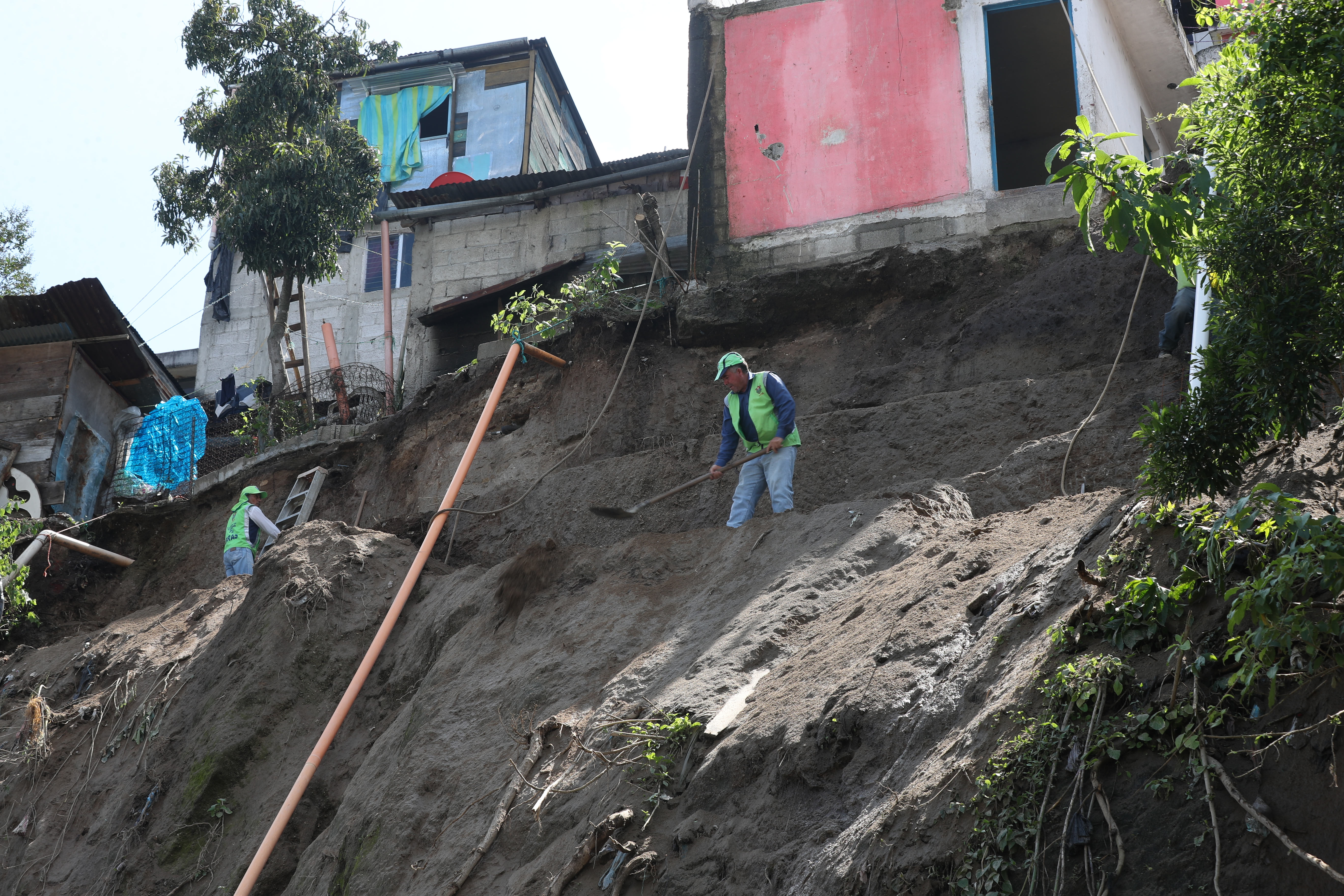 Personas trabajan en el lugar para poner una pared en el lugar del deslizamiento. 