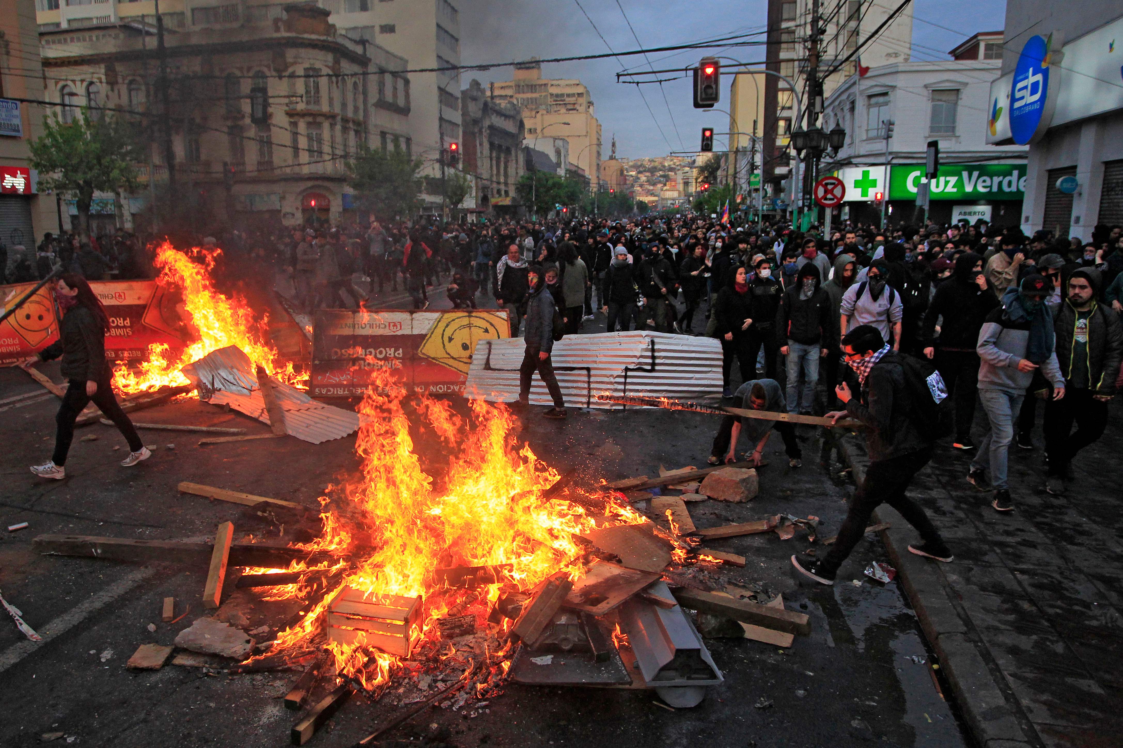 Manifestantes encendían hogueras en Vaparaíso, durante protestas contra el incremento al costo del metro de Santiago de Chile. (Foto Prensa Libre: AFP)