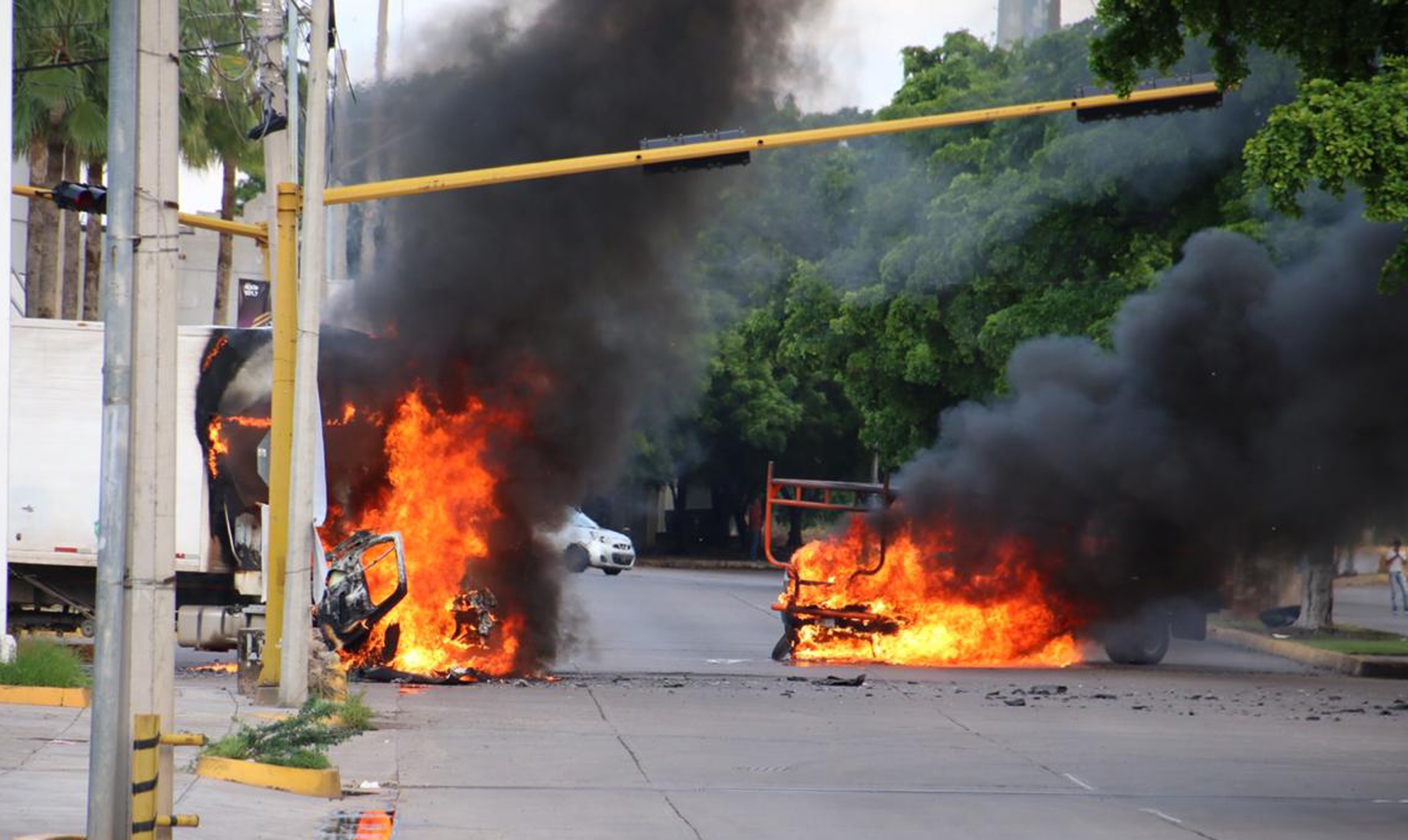 vehículos se incendian en una calle de Culiacán, Sinaloa, México, durante los ataques del 17 de octubre de 2019 para impedir la captura del hijo del Chapo Guzmán. (Foto Prensa Libre: AFP)
