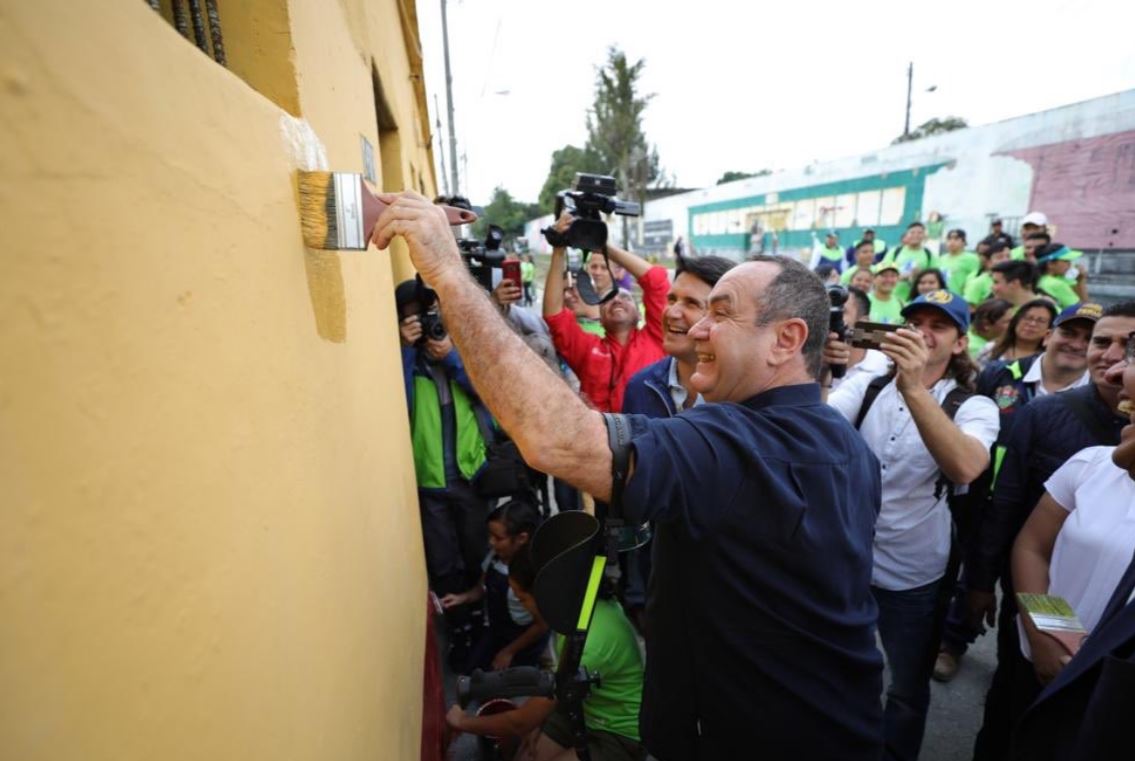 El presidente electo Alejandro Giammattei pinta una de las casas por donde pasará el tren junto al alcalde capitalino Ricardo Quiñónez. (Foto Prensa Libre: Municipalidad de Guatemala)