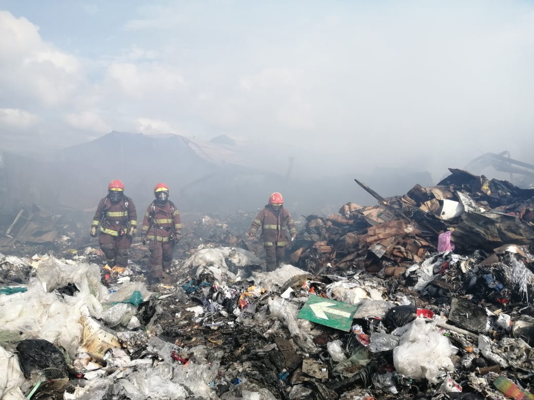 Bomberos caminan revisando los escombros para detectar focos de fuego. (Foto Prensa Libre: Andrea Domínguez) 