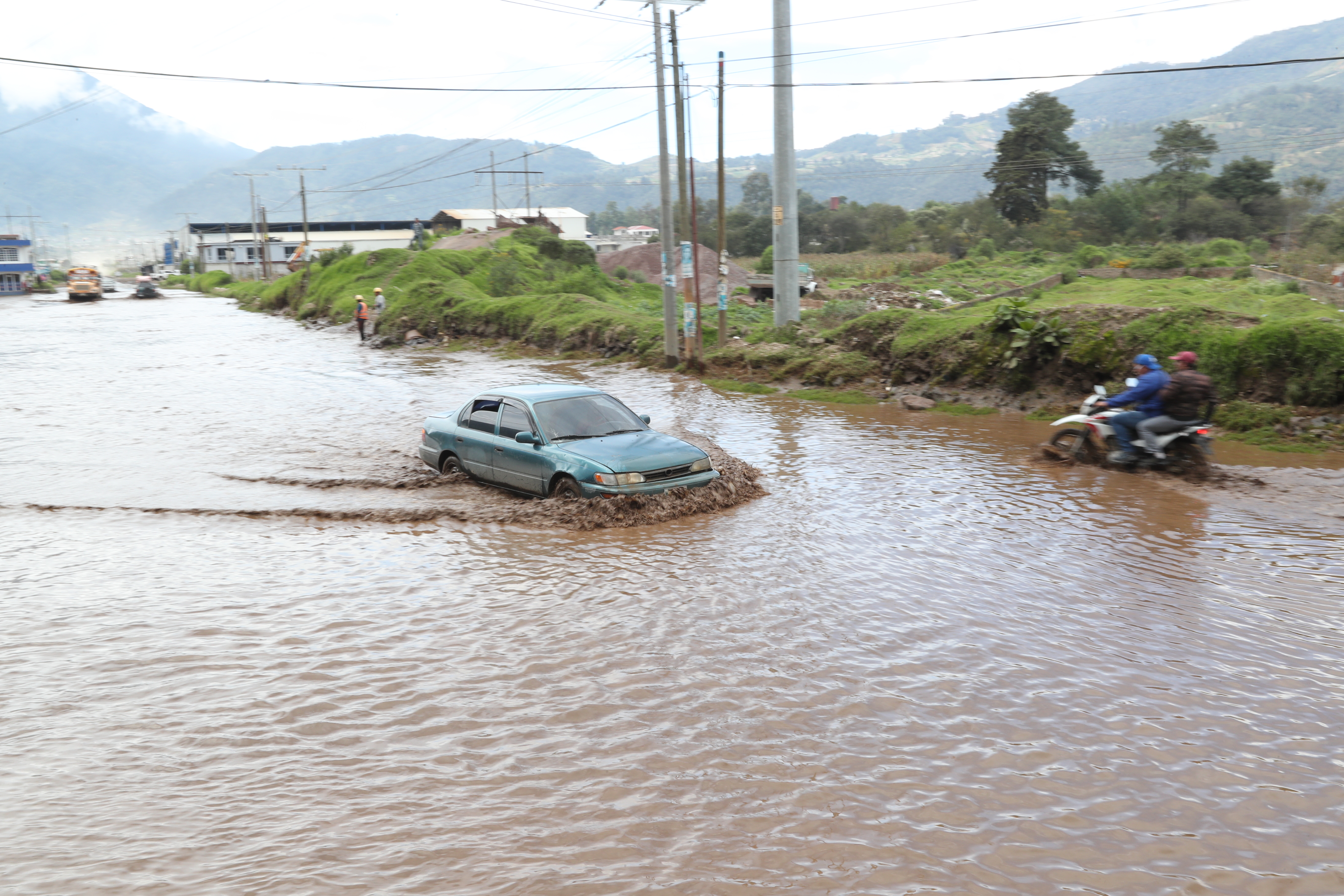 Vecinos dañan sus vehículos para poder desplazarse en la Puerta del Llano. (Foto Prensa Libre: María Longo) 