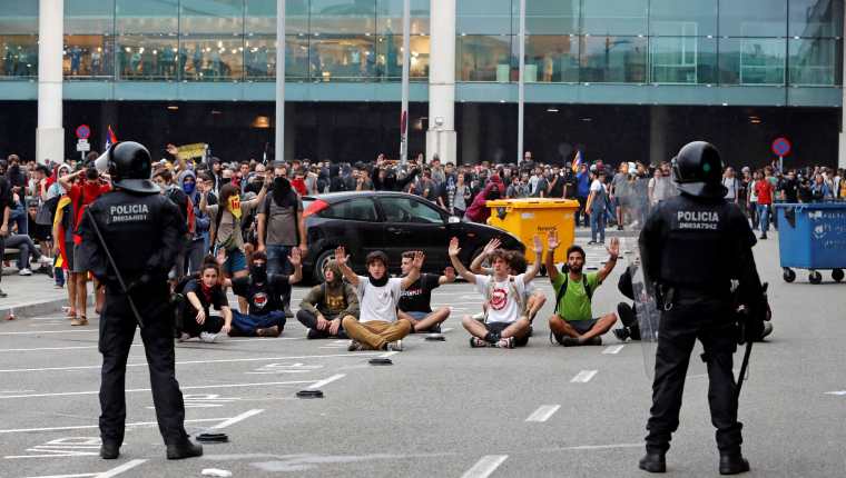 Autoridades controlan a las personas que se concentraron en el Aeropuerto del Prat, Barcelona. (Foto Prensa Libre: EFE)