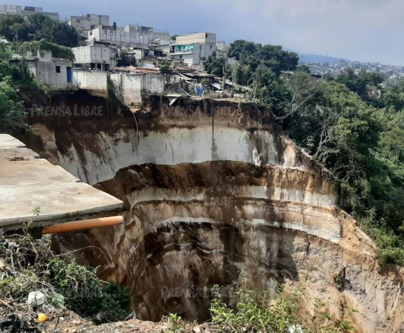 Dos viviendas cayeron al barranco en Peronia, Villa Nueva; otras ocho casas están en riesgo. (Foto Prensa Libre: Andrea Domínguez).