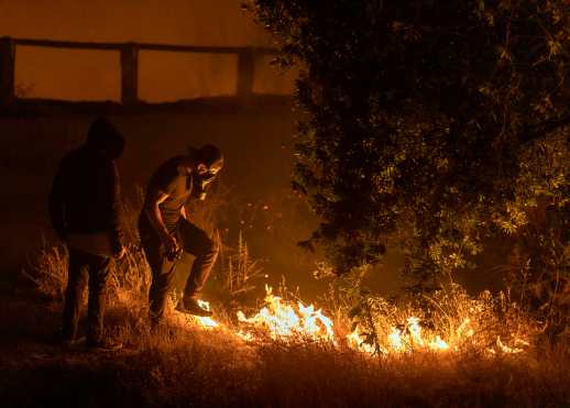 Un hombre pisa las llamas del incendio de Saddleridge en la sección Porter Ranch de Los Ángeles, California, en las primeras horas de la mañana del 11 de octubre de 2019. (Foto Prensa Libre: AFP)