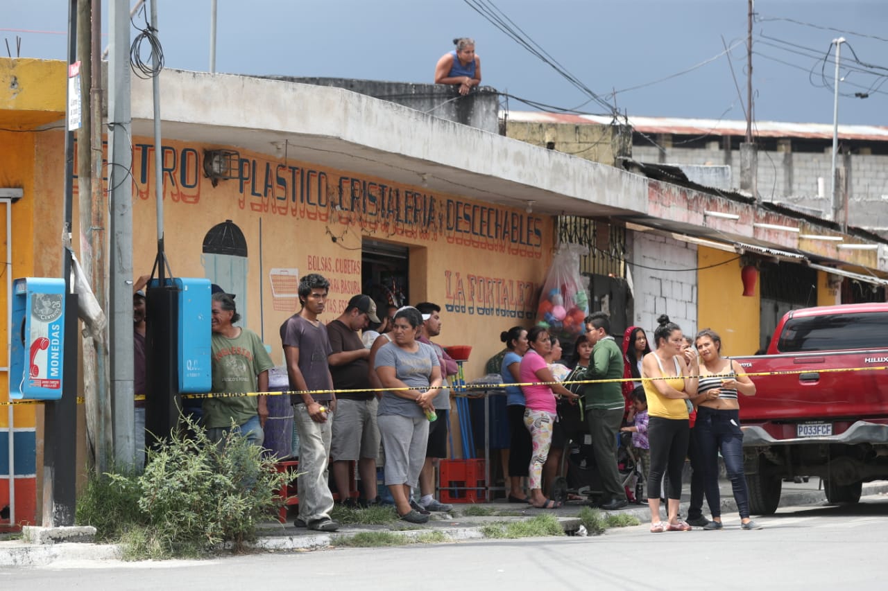 Vecinos de Villa Hermosa observan el trabajo del Ministerio Público en el lugar donde murió un trabajador la mañana del martes 8 de octubre. (Foto Prensa Libre: Óscar Rivas)