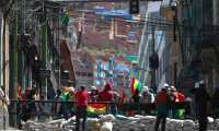 Ciudadanos bolivianos resguardan un ingreso a Plaza Murillo, donde los policías se replegaron, este sábado en La Paz. (Foto Prensa Libre: EFE)