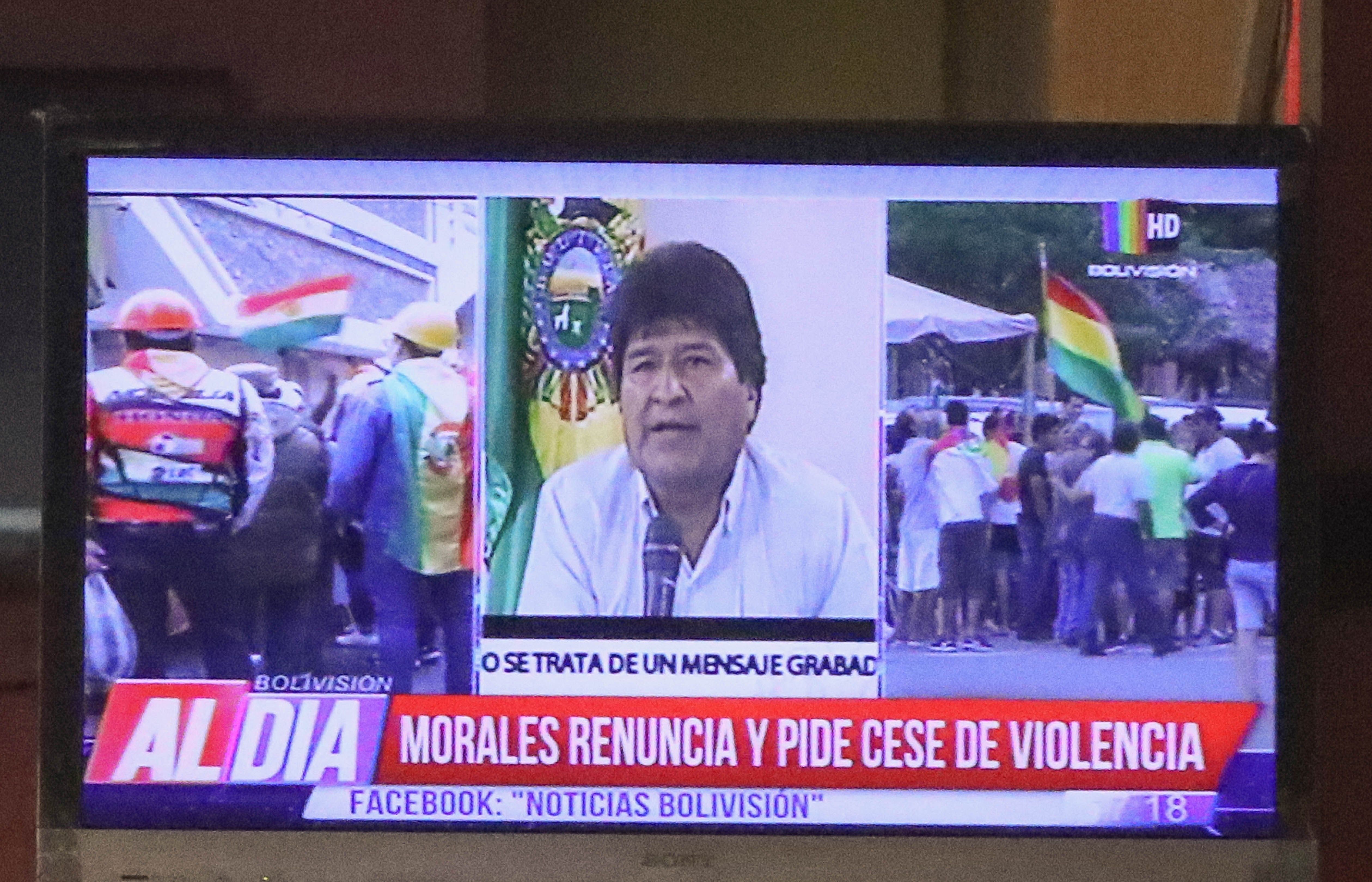 Ciudadanos bolivianos observan en una pantalla la renuncia del presidente de Bolivia, Evo Morales. EFE/Martin Alipaz