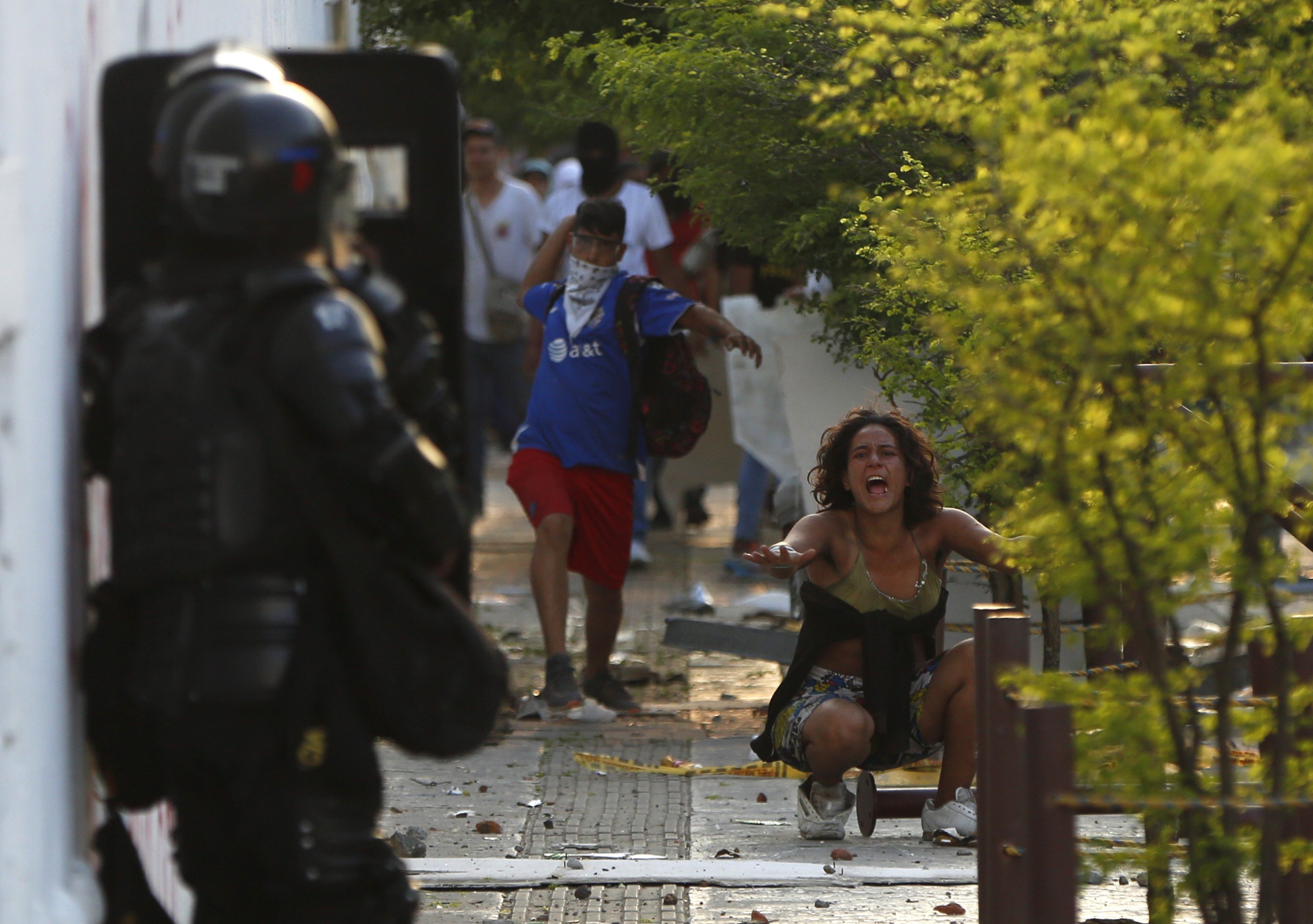 Una mujer grita entre un manifestante que enfrenta a la policía durante el desarrollo de las protestas y movilizaciones por el denominado Paro Nacional. (Foto Prensa Libre: EFE)
