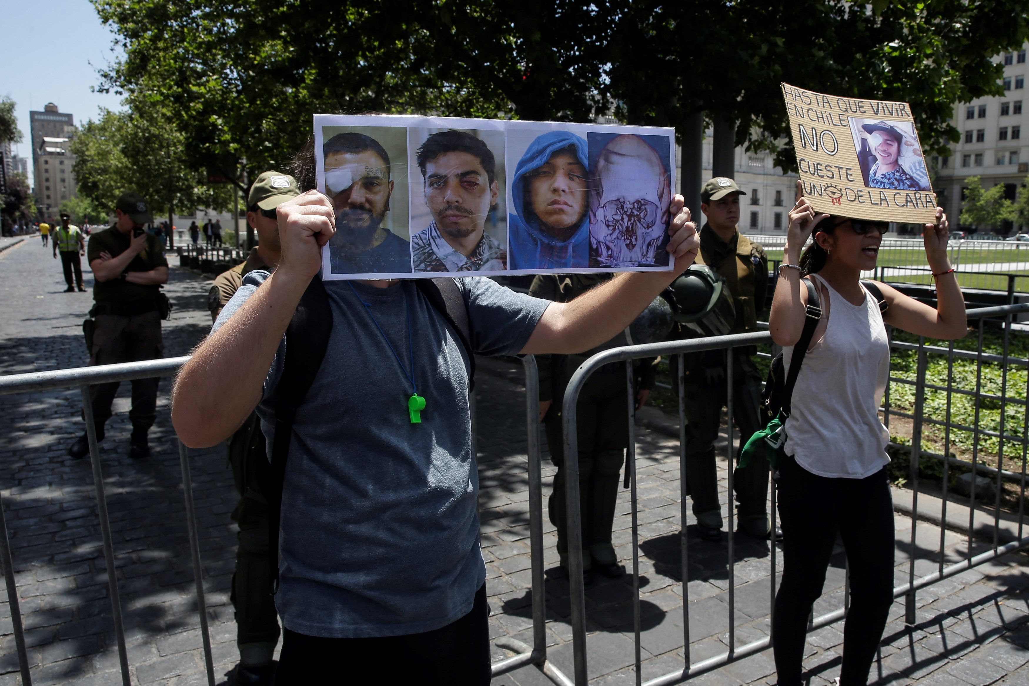 Manifestantes portan carteles con fotografías de algunos de los más de 200 heridos oculares, con pérdida parcial o total de la visión por el uso de balines y otras municiones utilizadas por Fuerzas Especiales de Carabineros. (Foto Prensa Libre: EFE)