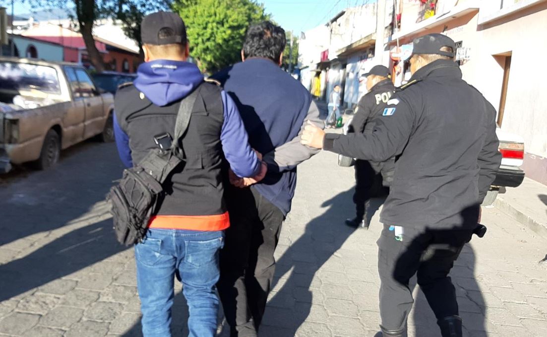 Agentes de la PNC trasladan a uno de los detenidos durante los operativos. (Foto Prensa Libre: PNC).