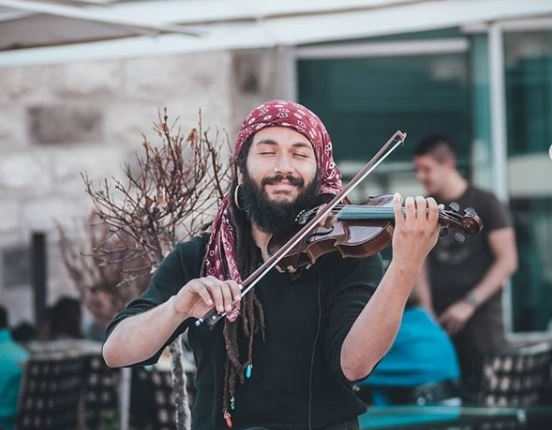 El músico guatemalteco Abdul Medina ejecuta su violín en Budva, Montenegro. (Foto Prensa Libre: Tomada de Instagram).
