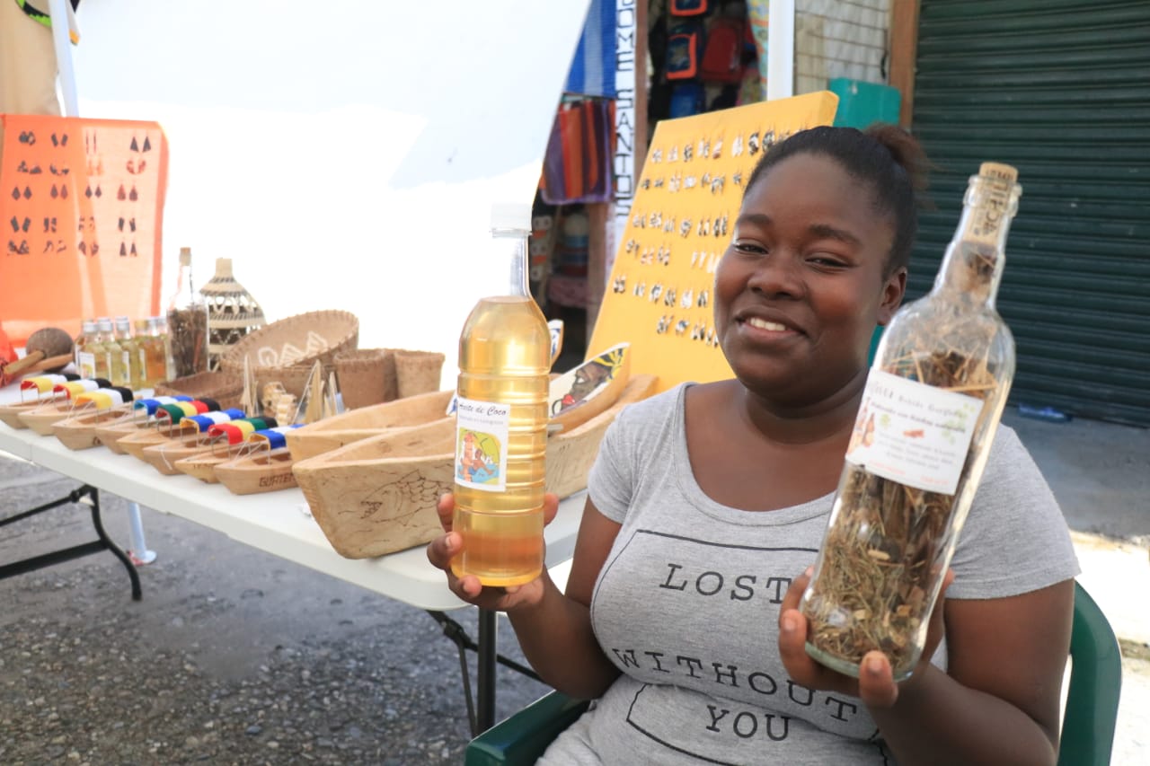 Una mujer garífuna muestra un aceite de coco y una bebida llamada Gifitti, productos de consumo popular en Lívingston, Izabal. (Foto Prensa Libre: Dony Stewart)